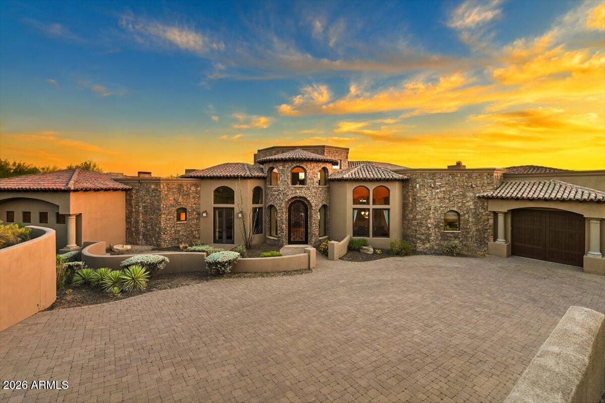 Golf Membership Available! Positioned on a premium homesite with sweeping mountain, sunset, and city light views, this expansive Desert Mountain residence offers over 6,600 square feet of thoughtfully designed living space and exceptional indoor-outdoor living.

The open floor plan features four ensuite bedrooms, a dedicated study, theater room, wine room, exercise room, and a spacious loft/game room that is pre-plumbed for an additional bath. Quality finishes, generous living areas, and a highly functional layout create a home that is equally suited for everyday living and entertaining.

Outdoor living takes center stage with more than 1,000 square feet of covered patio space overlooking the surrounding desert landscape. Enjoy a negative-edge pool and spa, outdoor fireplace, built-in kitchen, and multiple gath designed to capture the spectacular Arizona sunsets and sparkling city lights.
Additional highlights include an oversized three-car garage with epoxy flooring and a flexible floor plan that offers privacy and comfort for family and guests alike.

Located within the guard-gated community of Desert Mountain, memberships are available separately through the Desert Mountain Club, providing access to world-class golf, dining, fitness, tennis, pickleball, hiking trails, and an unmatched desert lifestyle.