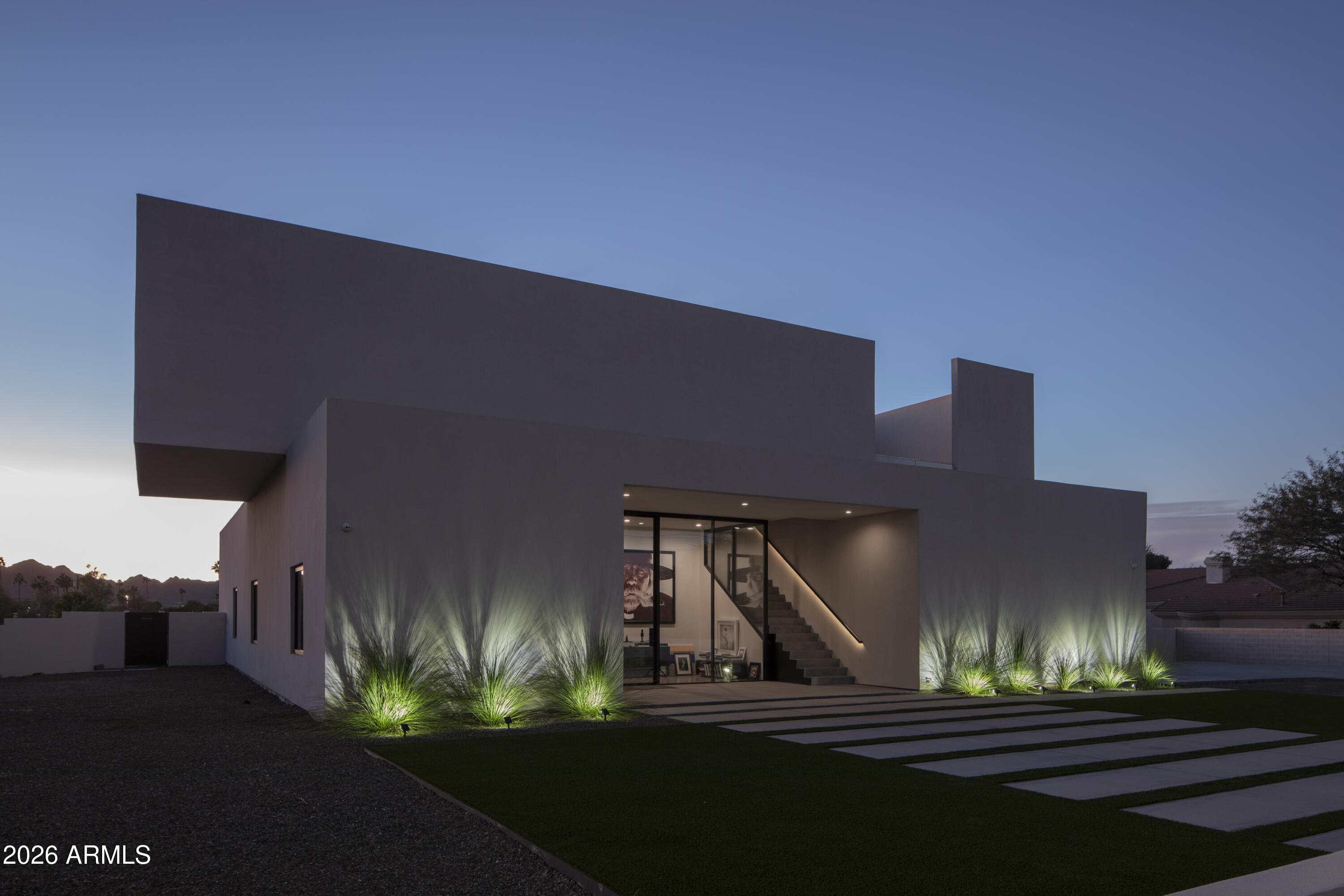 Perched near Paradise Valley's finest amenities on the northern edge of the Phoenix Mountain Preserve, this 2021 architectural gem crafted by acclaimed architect Bradley Edwards, is more than a home: it's a sculptural expression of modern design, serenity, and seamless integration with nature. Originally conceived as a private creative retreat for a photographer, this over 4,000 sq ft residence commands more than an acre of pristine desert terrain with direct access to hiking trails and unobstructed views of iconic Piestewa Peak. Inside, clean lines and dramatic volumes define the space. Polished exposed aggregate concrete floors, 12-foot ceilings, and floor-to-ceiling Fleetwood retractable glass walls create a fluid connection between indoors and out effortlessly merging light, landscape and architecture. The heart of the home is built for gathering and entertaining, with dual chef-grade kitchens one inside, one alfresco featuring sleek quartz counters, custom white oak cabinetry, and top-tier smart appliances. Five bedrooms and 3.5 bathrooms provide luxurious space for family and guests. Step outside to a private oasis with a resort-style pool, spa, and expansive rooftop decks that capture golden sunsets and panoramic mountain views. With no HOA restrictions and ample space to expand, this estate is the perfect canvas for your vision. This is desert modernism at its most refined, offering absolute privacy, architectural prestige, and proximity to everything including world class dining, shopping, hiking and golf.