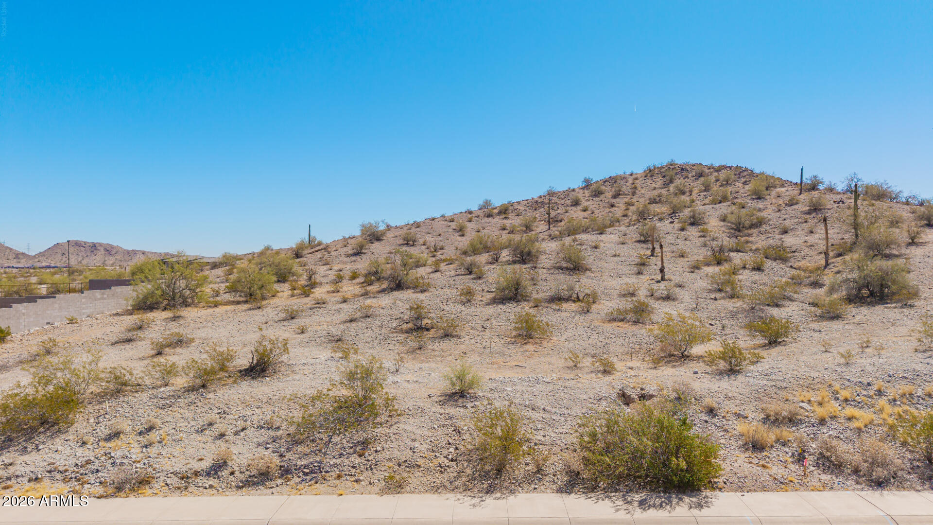 Discover the perfect canvas for your forever home on this East/West-facing custom lot in Estrella! This expansive 2/3 acre parcel boasts tranquil mountain views that create a beautiful backdrop for everyday living.  Nestled in Estrella Mountain Ranch, the private gated enclave of Sonoran Vistas has full access to the resort-style amenities including lakes, resident clubs with pools and fitness centers, championship golf course, scenic trails, parks, and recreational facilities. This custom home site is ideally situated just  a short walking distance and mere minutes from shopping, dining, and convenient access to all that the masterplanned community of Estrella has to offer. Seize the opportunity to own a piece of serenity!