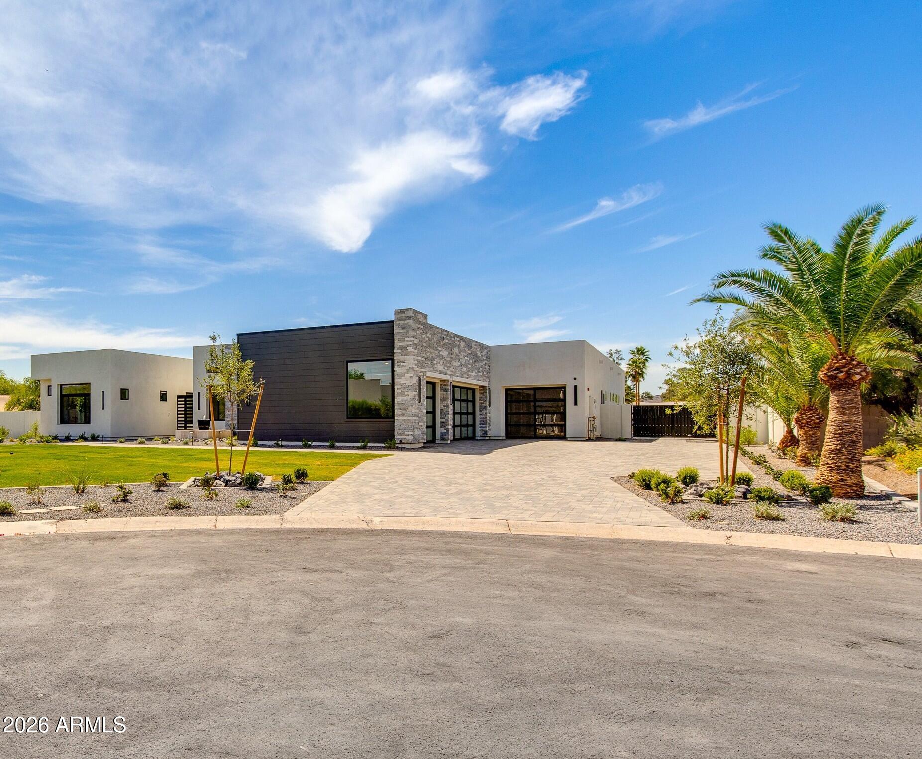 An architectural statement of modern desert luxury, this newly constructed Paradise Valley residence blends sophisticated design with effortless livability. Set on a generous lot, the home is defined by clean contemporary lines, soaring ceilings, and walls of glass that invite natural light and frame seamless indoor-outdoor living. At the heart of the home, the show-stopping kitchen is both refined and functional, featuring premium appliances, custom cabinetry, designer finishes, and dual islands ideal for entertaining. Open living and dining spaces flow beautifully to covered outdoor living areas, creating the perfect environment for hosting or relaxing in the Arizona sun. Private guest suites and flexible living spaces provide comfort and versatility, while the primary retreat offers a serene escape with spa-inspired finishes and a true sense of tranquility. The resort-style backyard is designed for year-round enjoyment, complete with a sparkling pool, shaded lounge areas, outdoor kitchen, sports court, putting green and ample space for entertaining under the stars.
Located in one of Paradise Valley's most coveted neighborhoods, this exceptional home offers proximity to top-tier schools, luxury shopping, fine dining, golf, and world-class resorts--delivering timeless elegance, modern comfort, and the ultimate Arizona lifestyle.