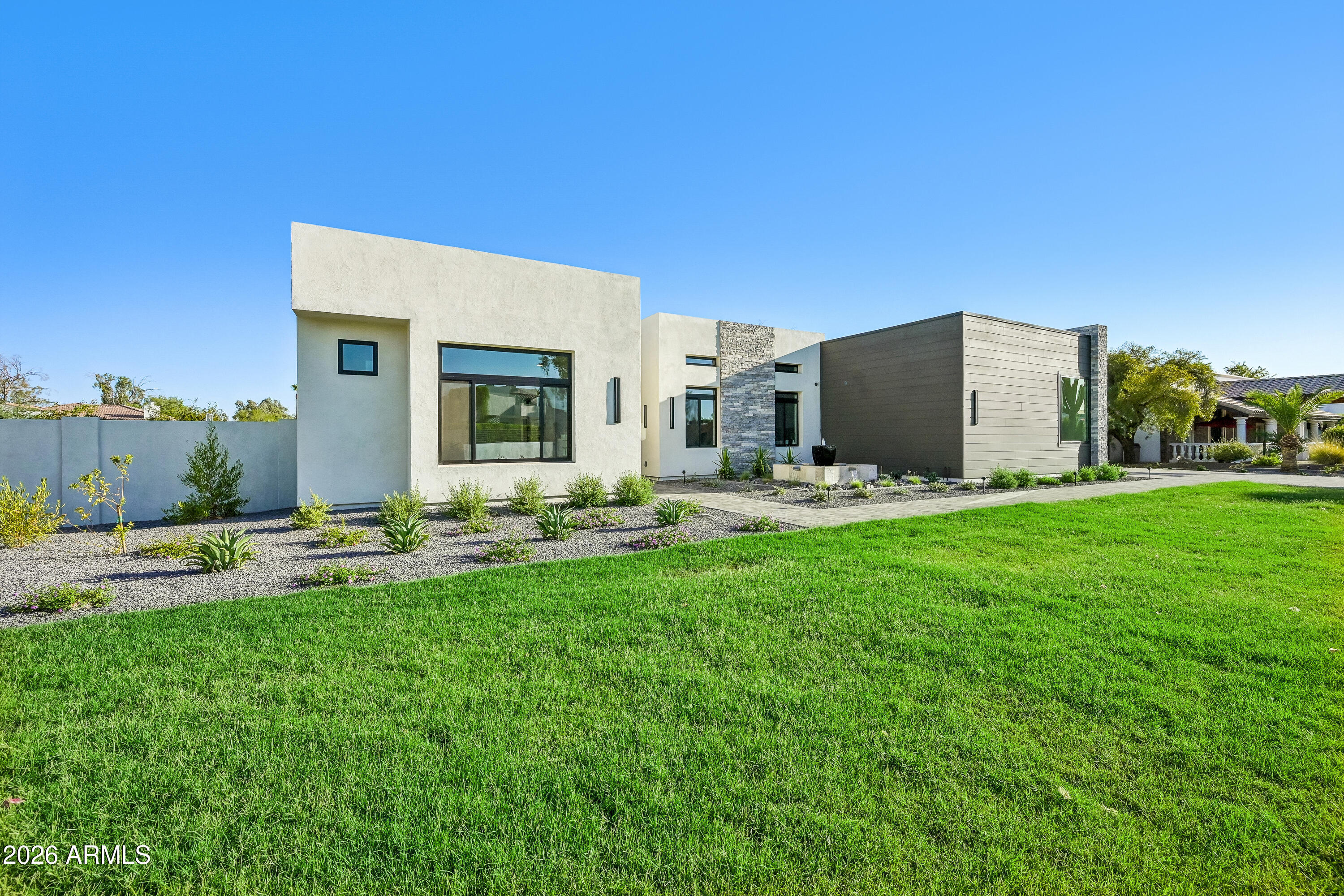 Complete, pristine, and ready for you! 
An architectural statement of modern desert luxury, this newly constructed Paradise Valley residence blends sophisticated design with effortless livability. Set on a generous lot, the home is defined by clean contemporary lines, soaring ceilings, and walls of glass that invite natural light and frame seamless indoor-outdoor living. At the heart of the home, the show-stopping kitchen is both refined and functional, featuring premium appliances, custom cabinetry, designer finishes, and dual islands ideal for entertaining. Open living and dining spaces flow beautifully to covered outdoor living areas, creating the perfect environment for hosting or relaxing in the Arizona sun. Private guest suites and flexible living spaces provide comfort and versatility, while the primary retreat offers a serene escape with spa-inspired finishes and a true sense of tranquility. The resort-style backyard is designed for year-round enjoyment, complete with a sparkling pool, shaded lounge areas, outdoor kitchen, sports court, putting green and ample space for entertaining under the stars.
Located in one of Paradise Valley's most coveted neighborhoods, this exceptional home offers proximity to top-tier schools, luxury shopping, fine dining, golf, and world-class resorts--delivering timeless elegance, modern comfort, and the ultimate Arizona lifestyle.