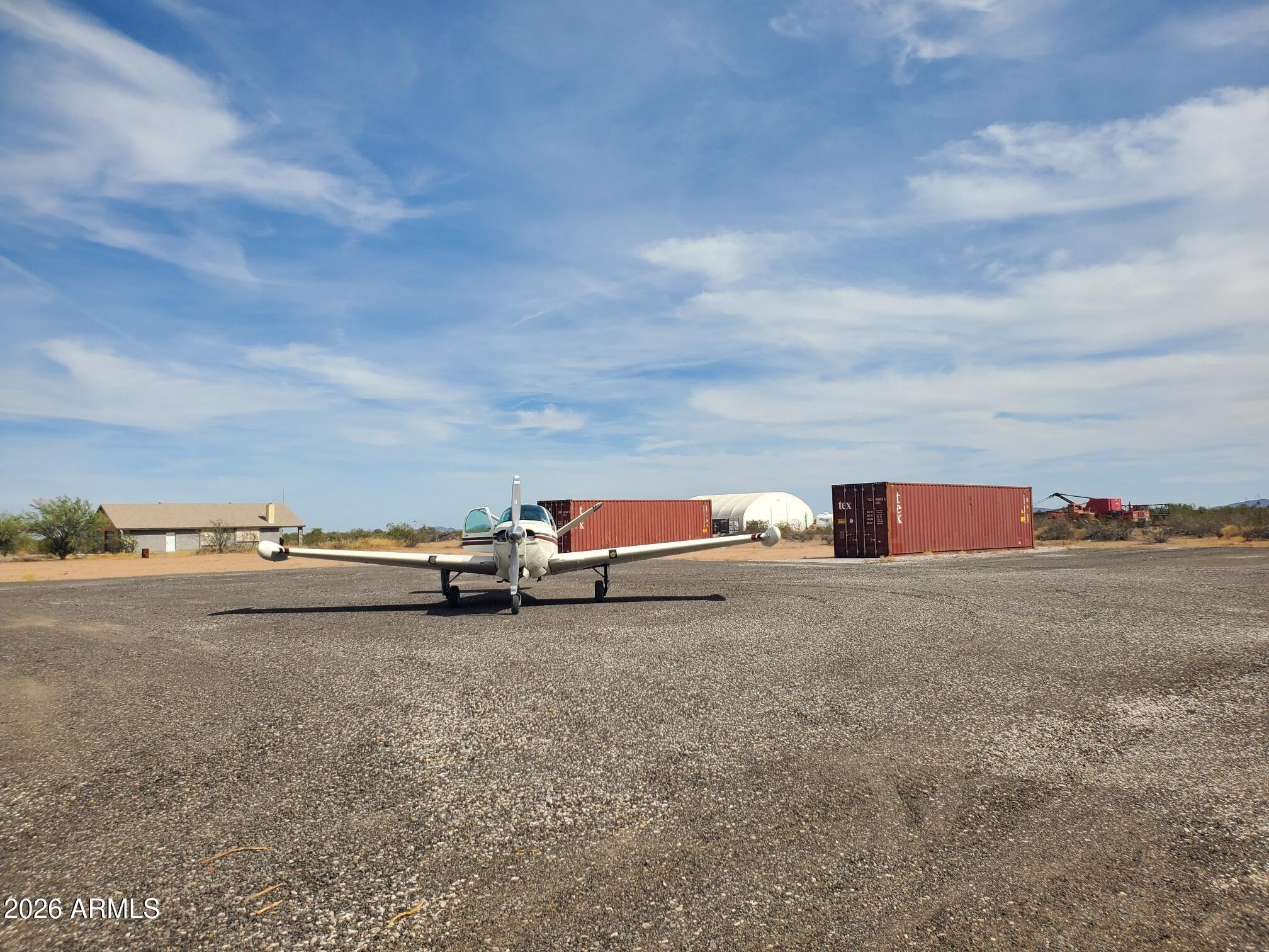 Rare opportunity to acquire a 10-acre aviation property in a developing Arizona airpark, featuring direct primitive taxiway access in close proximity to the threshold of a 5,000-foot private runway (0AZ1) and a hangar shell currently under construction--ready for buyer completion. This parcel is surveyed complete and can be divisible into four (4) 2.5-acre airpark lots, offering flexibility to create a private aviation estate, a pilot enclave, or a small airpark development. The property is located approximately 300 feet from the runway, consistent with many established airparks. The airpark is in an early-stage development phase, providing buyers the advantage of early access and long-term upside. CCRs are forthcoming and expected to support residential aviation use for homes and hangars. The hangar has been started, allowing the buyer to complete and configure it to suit personal preferences-saving time and initial site planning versus raw land.  Early stage airpark with long term upside!  Cash friendly transaction. Separate from sale, there is a lightly used tractor, flat bed trailer and other equipment to facilitate DIY grading, material moving, hauling, etc.  Water source within 500 feet.