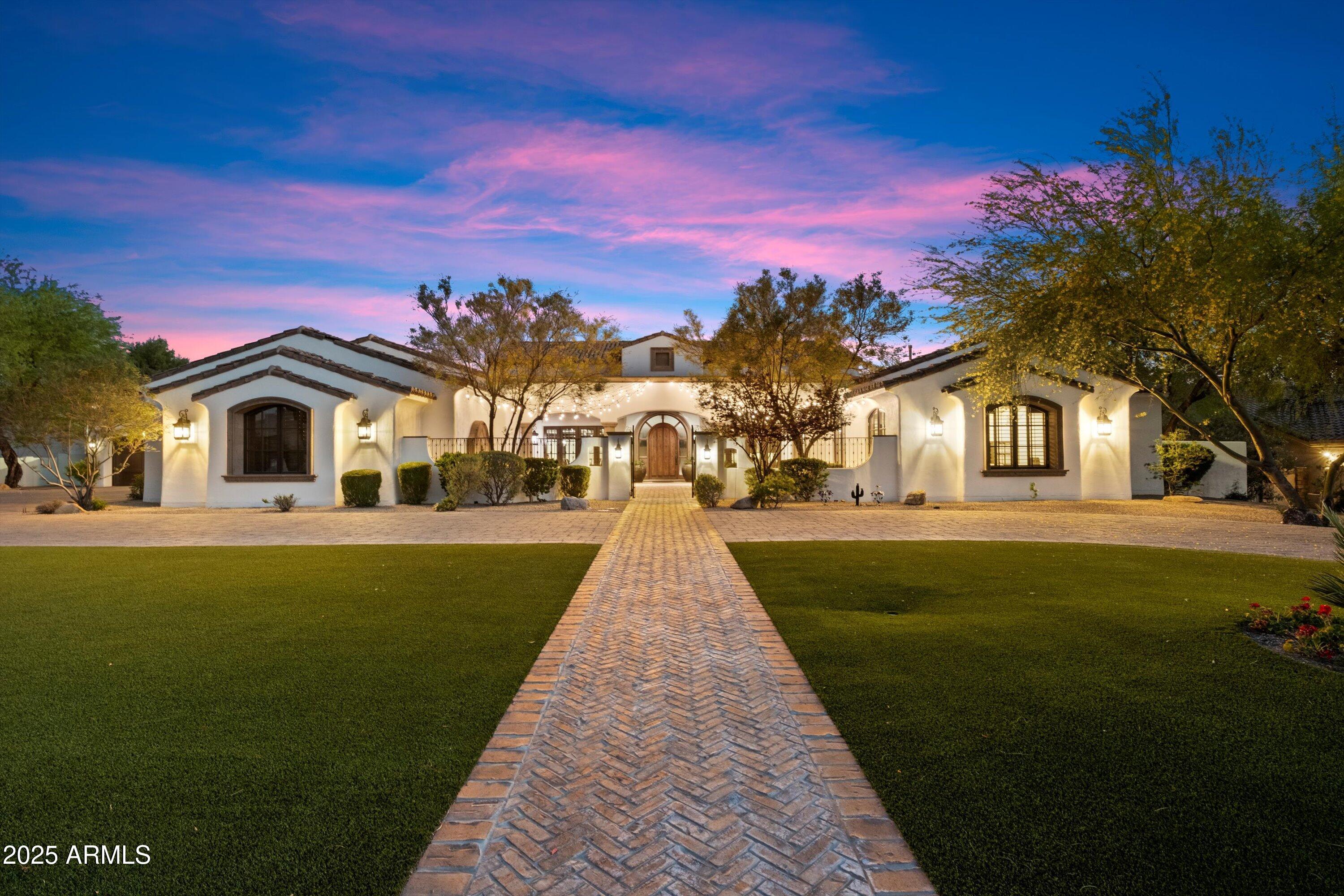 Welcome to refined living in this custom-built 10,871 square foot estate, perfectly situated on nearly an acre in the prestigious Cactus Corridor. The gourmet kitchen shines with Wolf and Sub-Zero appliances, a built-in Miele coffee maker, dual farmhouse sinks, three dishwashers, and a generous marble island-ideal for entertaining or cozy evenings at home. A sleek powered pocket door unveils a resort-style backyard, complete with a pool, spa, firepit, and vibrant landscaping featuring citrus trees and low-maintenance turf, effortlessly uniting indoor elegance with outdoor allure. Monarch plank European oak floors, travertine touches, and lofty vaulted ceilings lend a welcoming yet upscale ambiance, complemented by a sophisticated wood-detailed office-all supported by a 28.8 kW solar system keeping the average monthly bill at a remarkable $205.89. For a playful twist, enjoy an indoor basketball court paired with a adaptable bonus room, ready to become your gym, home theater, or gaming retreat. Four roomy bedrooms offer restful sanctuaries, alongside a teen room, two offices, and spacious living, dining, and family areas tailored to every lifestyle. Car aficionados will revel in the temperature-controlled six-car garage with ample storage, perfect for prized vehicles or hobbies. A Control4 automation system streamlines lighting, music, and temperature control, enhancing the home's contemporary flair. Nearly an acre of secluded grounds and a covered patio round out this remarkable estate, blending sophistication, comfort, and sustainable design in one extraordinary property.