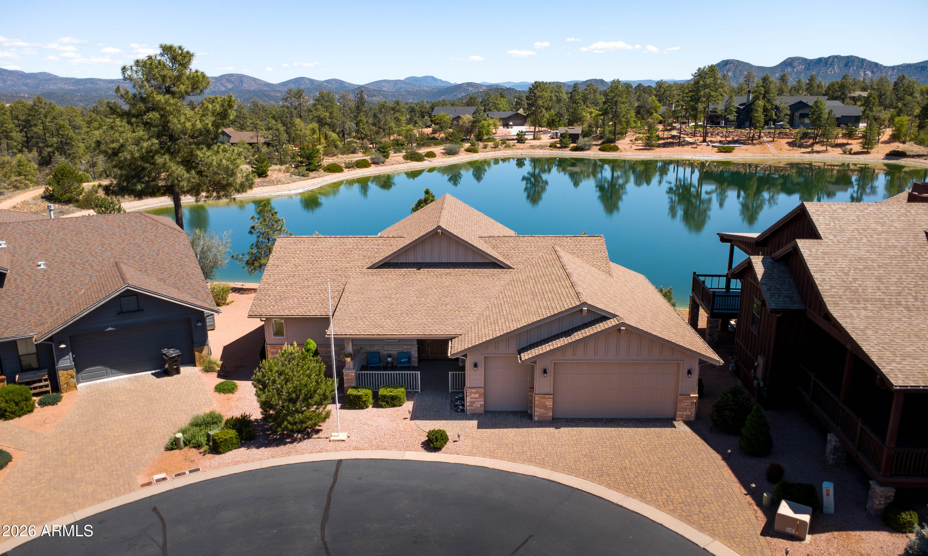 Waterfront property in the gated golf community of Chaparral Pines! This home boasts two primary bedrooms with private access to the expansive back deck. Built in 2017, the home sits on a quiet cul-de-sac and captures serene water and mountain views from nearly every room.
The split floor plan features two spacious suites with dual vanities, walk-in closets and outdoor access. The kitchen offers a gas range, stainless steel appliances, custom cabinetry, quartz countertops, a large island, and walk-in pantry.
Vaulted ceilings, 8' alder doors, wood flooring, fireplace, and no interior steps. The oversized 2.5-car garage includes an EV charger. Low-maintenance and ideal for full-time living or a lock-and-leave retreat.