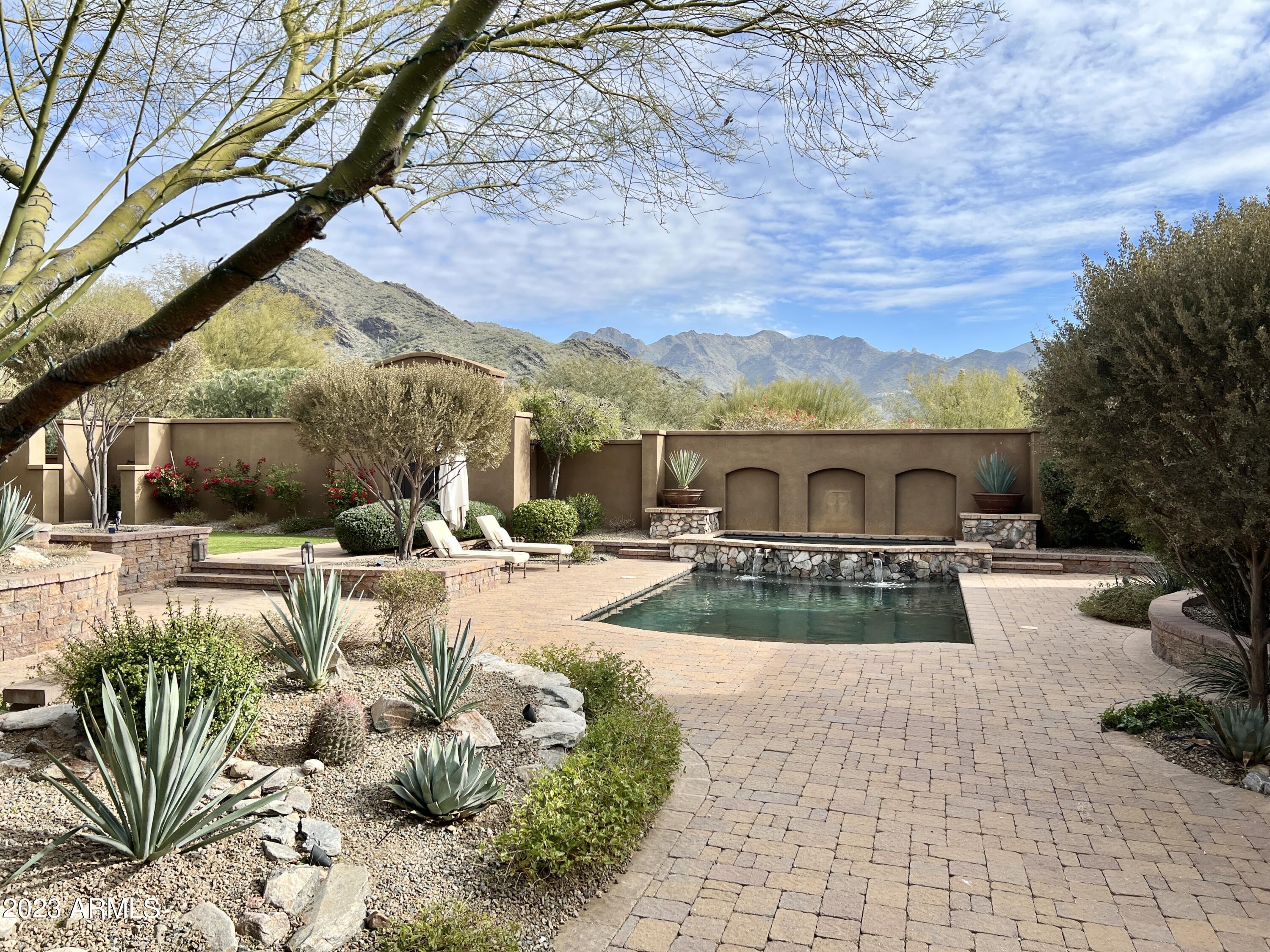 Beautifully designed Spanish Colonial residence in desirable guard gated golf community of DC Ranch Country Club. This extremely private estate on just under an acre, stays true to authentic Spanish design and architecture with exposed wood beams, corbels, wood head lintels and window sills, Cantera stone, Moreno tiled floors, DC Ranch stone, barrel roof tiles, Spanish tiles, antique bronze lighting and hardware and alder stained cabinets and closets with hand cast solid bronze hardware. Concealed from the road with surrounding walls, estate entrance is through 8' mesquite doors into lush central courtyard which acts as the center of the home. The estate layout wraps around lush central courtyard, with multiple exits taking you from indoors to out, seamlessly connecting your home to its environment, creating a sense of relaxation and a connection to nature. Courtyard has multiple private patios for both intimate and large gathering, with extended patio perfect to entertain with gas fireplace, entertainment TV niche, plus ample space for dining table, Dacor gas grill, PebbleTec pool and spa with waterfall, low maintenance artificial turf, large sun patio, and roof deck. The views of McDowell Mountain Range and Tom Thumb from courtyard, roof and every room cannot be understated. As you enter the home, the 15' ceiling entry draws you into this 4,395 sqft 4 bed 3.5 bath one story home. The horseshoe floor plan places the primary suite at the farthest end of the property near the dedicated office. An additional en-suite bedroom is close to the music room and wine cellar which leads to the great room, formal dining room and bar. The gourmet kitchen boasts a Dacor six burner gas cooktop, Dacor double ovens, Miele espresso center, wine and beverage cooler, 48" Sub-Zero side by side with millwork panel doors, Asko dishwasher and gorgeous breakfast room with amazing views to courtyard. The opposite side of the house contains the Home Theatre room, 2 additional bedrooms joined by a jack and jill bath, landing zone right off the 3 car plus garage (space to add your golf cart). DC Ranch has golf course with optional membership plus an extensive community center containing meeting rooms, a workout facility, pool and tennis courts. Please schedule a private showing to appreciate the craftsmanship, charm and uniqueness of the this property!