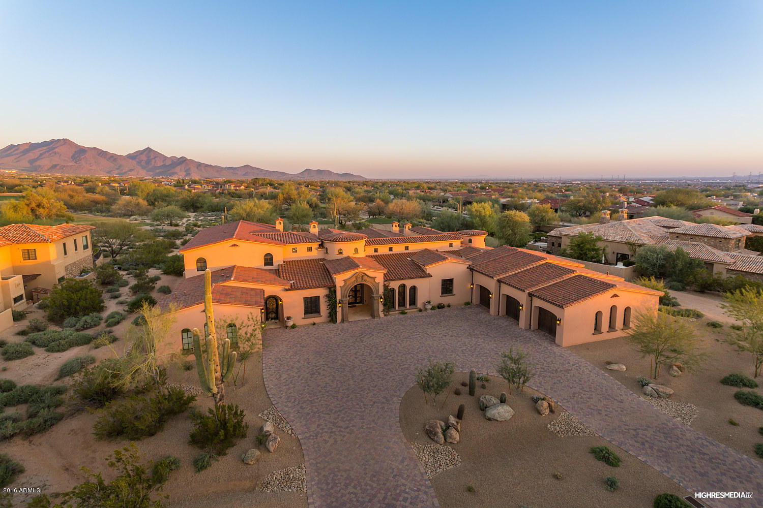 One of Grayhawk’s finest residences, this custom estate sits along the 12th hole of the Raptor course, designed by Tom Fazio, with city and mountain views. A light and airy color palette pays homage to a Santa Barbara-inspired interior with the use of natural stone, rich woods, clerestory windows and custom ironwork. The formal living room is dramatic with a large Cantera fireplace and retractable glass wall that hide seamlessly for an indoor/outdoor feel. The dual island kitchen is envious with the brick multi-barrel ceiling, walk-in pantry and commercial quality appliance package. Open to the great room with wet bar and Cantera fireplace, it has a casual dining space with circular ceiling detail and French door to the backyard. The formal dining room is spacious and offers a temperature controlled space to create your personal wine cellar. The owner's retreat is tucked away with a beautiful spa-style bath, separate tub & shower, two wardrobe centers and a spacious bedroom with Cantera fireplace, wood beamed ceilings and French doors to the outdoor terrace. Multiple guest suites, a private theater, office, fitness room, upstairs game room with balcony and attached guest casita offer additional spaces to enjoy.