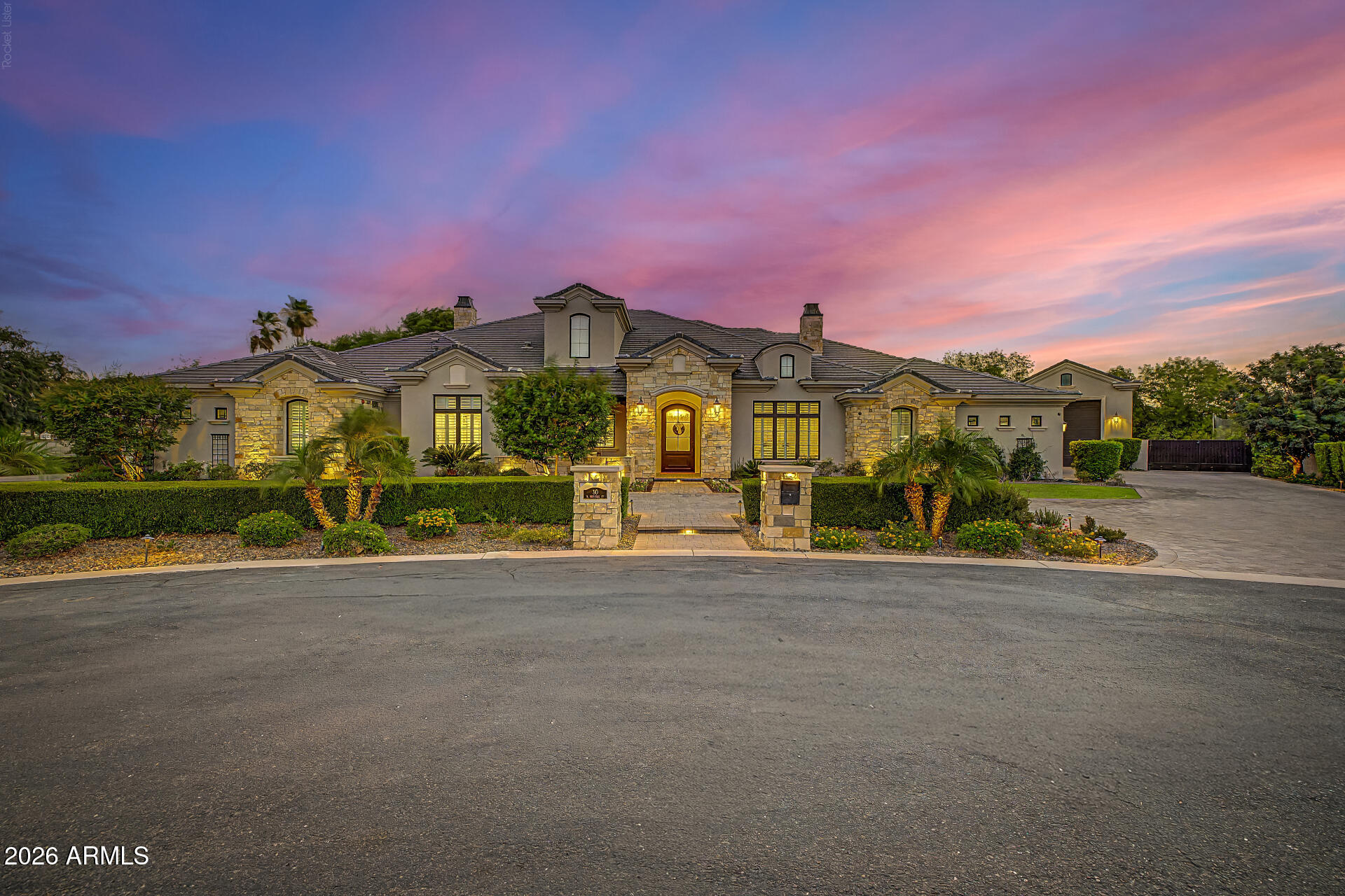 Luxury, flexibility, and timeless craftsmanship come together at this extraordinary custom estate in one of Gilbert's most exclusive gated enclaves. Located on just under an acre in a private cul-de-sac of only seven homes, this stunning 6,055-square-foot residence offers an opportunity that is rarely found in today's market. Built in 2018, the property features a beautifully designed 4,055-square-foot main home along with a completely separate 2,000-square-foot private casita--all under one roof. With its own entrance and attached two-car garage, the casita is ideal for multi-generational living, guests, a private office, or long-term flexibility. Inside the main residence, every detail reflects quality craftsmanship. Wide-plank hardwood flooring, custom millwork, designer lighting.... elegant ceiling treatments, and luxurious finishes create a warm yet sophisticated atmosphere. The thoughtfully designed split floor plan includes two spacious ensuite bedrooms in addition to the owner's suite. Both with private baths and walk-in closets, multiple living spaces, and a generous flex room that can easily adapt to your lifestyle. The chef's kitchen is the centerpiece of the home, featuring an oversized quartz island, premium appliances, custom cabinetry, and an incredible walk-in pantry with abundant built-in storage. The owner's retreat is a private sanctuary with direct access to the backyard through expansive glass doors, creating the perfect indoor-outdoor living experience. Outside, you'll find an entertainer's dream with a large covered patio, custom pavers, built-in BBQs and smoker, outdoor fireplace, playground, expansive grassy area, oversized RV garage, RV gate, and plenty of room for additional amenities. Additional highlights include a three-car garage for the main residence, attached two-car garage for the casita, whole-home audio system, security system, and exceptional custom storage throughout. Just minutes from Downtown Gilbert's acclaimed restaurants, shopping, entertainment, and convenient freeway access, this exceptional estate offers luxury living without compromise.