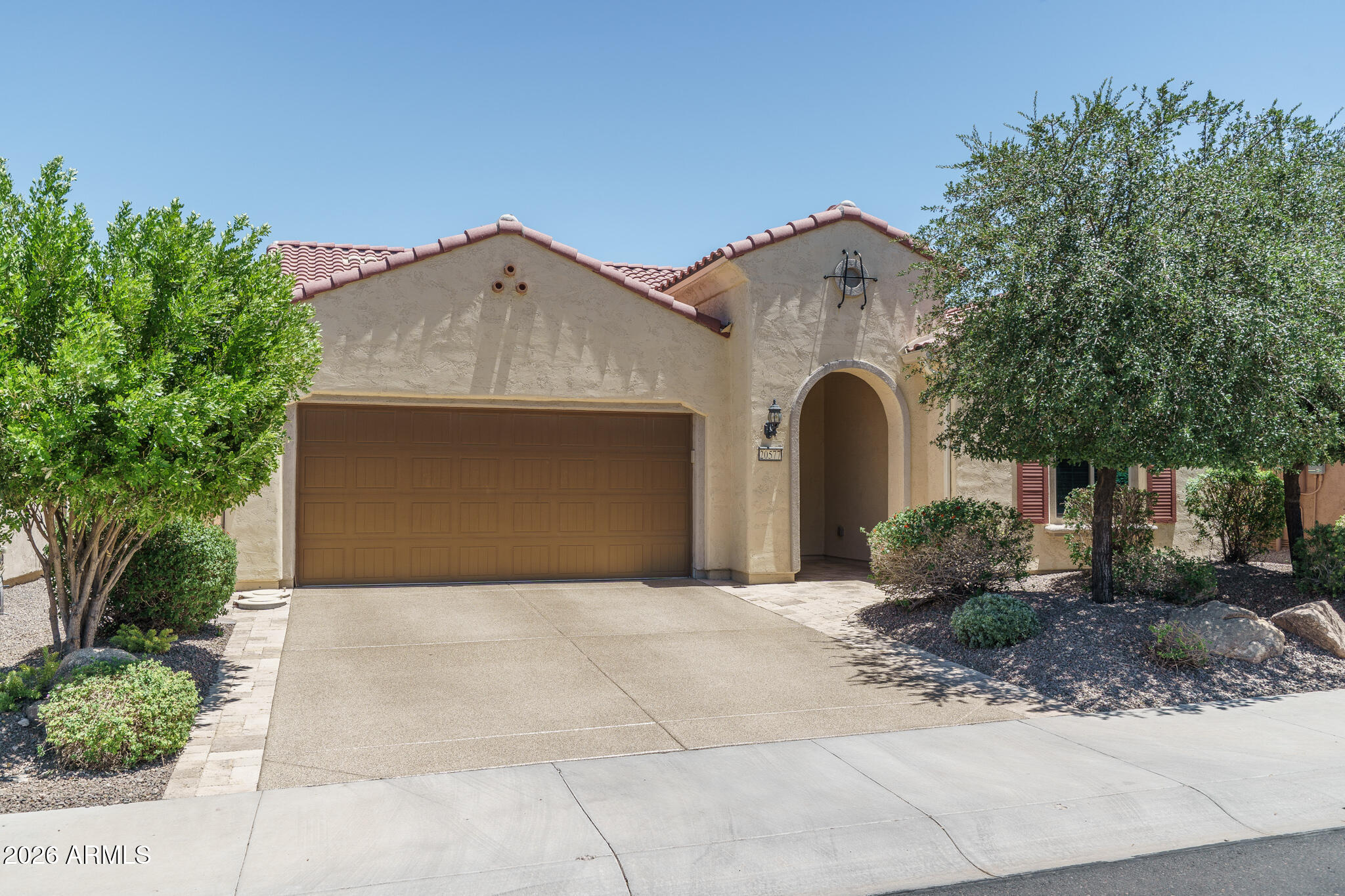Welcome to this beautifully upgraded extended Preserve model, a move-in ready retreat designed for the active adult seeking an elegant year-round home or a lock-and-leave seasonal escape. This 2-bedroom residence features en-suite baths, an office with custom built-ins, and an open great room layout spanning 2,040 SqFt. The gourmet kitchen impresses with 42'' espresso soft-close cabinetry with crown molding and some glass-front uppers, granite counters, a tiled backsplash, stainless appliances including a gas cooktop, a walk-in pantry with decorative door, and a large island with pendant lighting. Sliding glass doors open to an expansive covered patio with pavers, ceiling fans, and recessed lighting--perfect for indoor-outdoor living. The low-maintenance backyard offers artificial turf, desert landscaping, block fencing, and paver pathways. A split layout ensures privacy, and the primary suite boasts a granite dual-sink vanity with makeup area, soaking tub, tiled shower with glass surround, and a custom walk-in closet. Additional highlights include laundry cabinetry, a soft-water loop, a guest powder room, and a 2.5-car garage with built-ins and epoxy driveway. All of this is set within a community offering world-class active-adult amenities--resort and lap pools, fitness centers, indoor walking track, pickleball and tennis courts, golf, and more--creating an exceptional lifestyle for full-time or part-time residents.