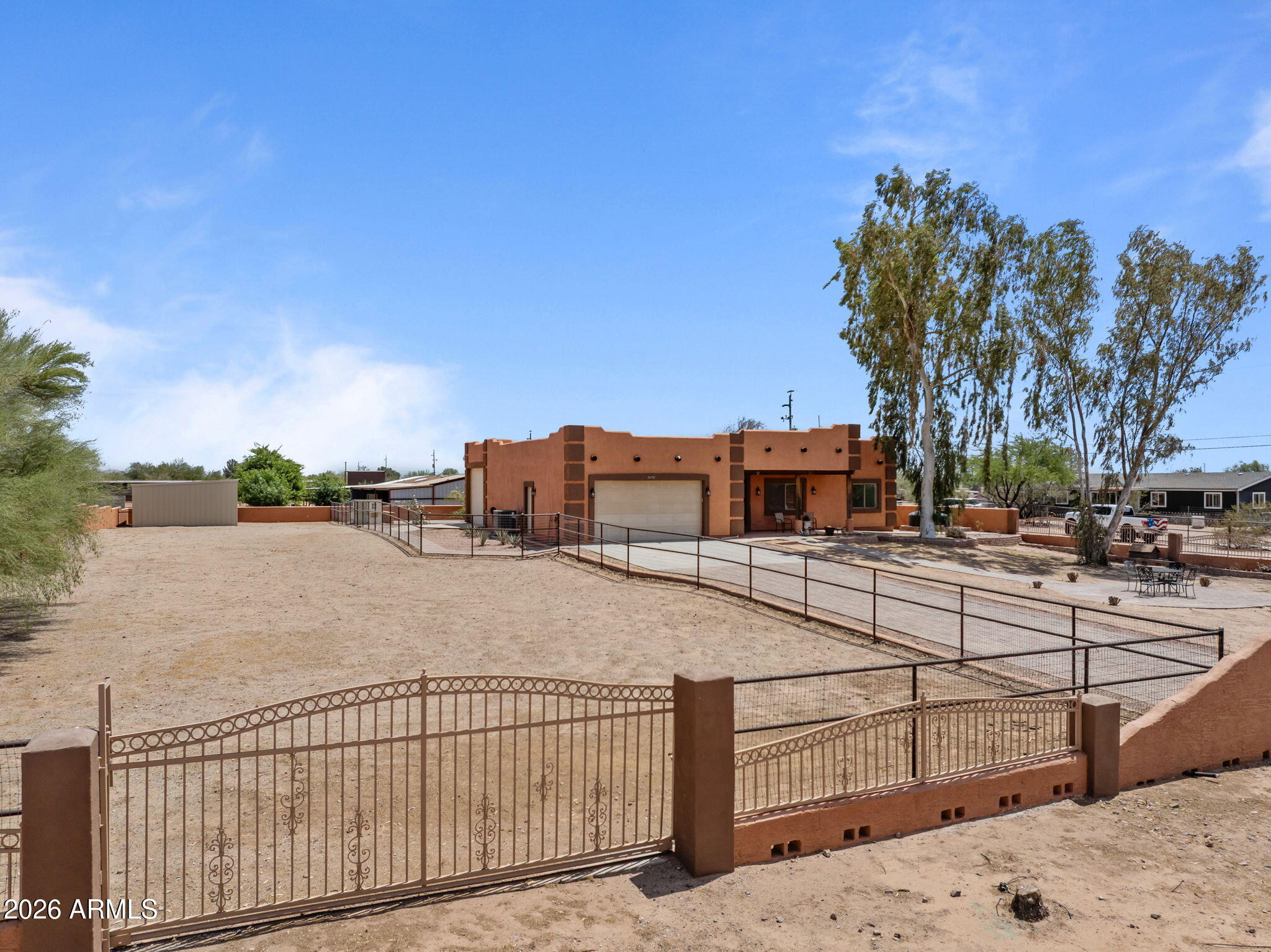 Welcome to this acre-plus property in Wittmann, offering plenty of space for horses, gardening, and enjoying the Arizona desert lifestyle. The property is fully fenced with perimeter chain-link no-climb fencing and includes two horse pens with a large turnout, making it ideal for horse owners & letting the dogs run freely or for those wanting room to spread out. The home features 3 bedrooms with a split floor plan, with the primary suite privately located away from the secondary bedrooms and offering its own en-suite bathroom. The secondary bedrooms are oversized, and every room features newly installed remote-controlled ceiling fans for added comfort. Additional living space includes two Arizona sunrooms, one located just off the primary bedroom, providing a perfect spot for relaxing or enjoying the surrounding views.
Recent updates include new interior paint, new flooring in the bedrooms, new trim throughout, a new AC unit, and a new hot water heater, while the main living areas feature tile flooring. The kitchen area includes a new refrigerator, and the laundry room has been upgraded with a new utility sink.
A separate RV/workshop garage provides excellent space for projects or storage and includes 220V power, a swap cooler, and ample workspace. A portion of the space has been converted but could easily be converted back to RV parking or additional storage if desired.The property also features a two-car garage, RV gate for easy access, and plenty of room for trailers and equipment.
Water is supplied through a shared well with five other properties, and there is a 1,600-gallon storage tank on site used for irrigation only. Located in a growing area with a new road planned for 227th Avenue, this property offers both privacy and future accessibility, making it a great opportunity to enjoy country living while still being within reach of nearby amenities.