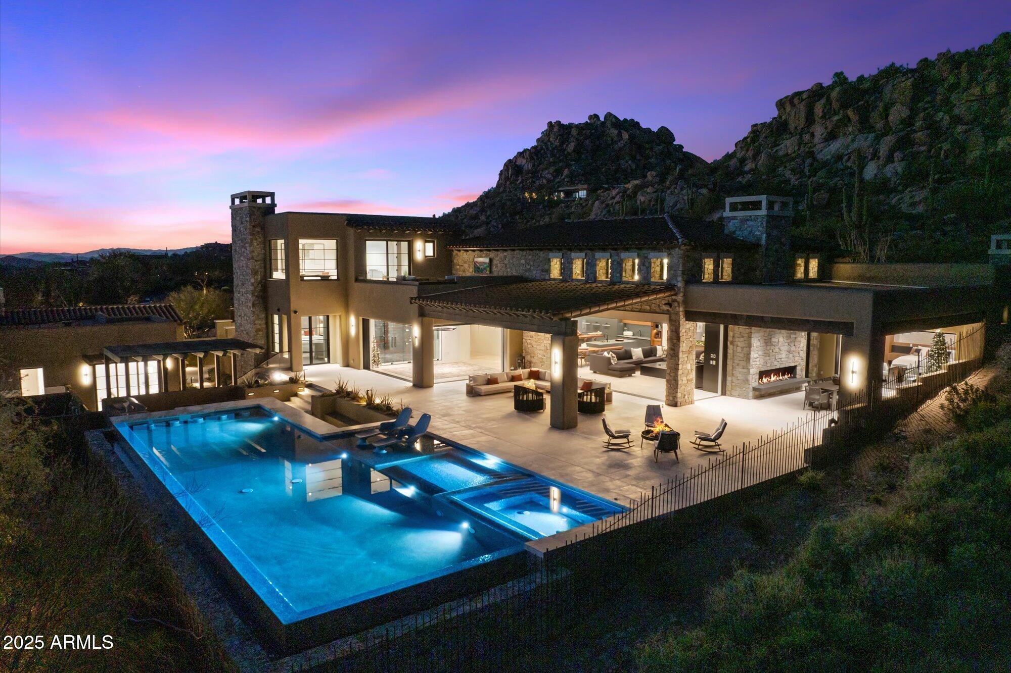 7 min walk to Four Seasons Resort; 1 of 11 custom homesites offering lifestyle amenities to Privada; North Scottsdale gated community on resort grounds, capturing panoramic views of Pinnacle Peak, Troon, McDowell Mountains, city lights, and golf course views. All on one-level living designed by POETZL architecture, offering a bonus room/office plus a spacious view deck on the second level. European in style with highest level of construction and building materials; the sliders, fireplaces, Linear cabinetry, Neolith stone countertops, sandblasted marble tiles, wide plank oak flooring, textured walnut millwork, Miele appliances, wine wall, show and prep kitchens are all the very best available.

The primary suite and 3 ensuite guest bedrooms each have their own wet bars... All bedrooms are on the main level.  The detached guest casita offers a family room with a fireplace, full kitchen, bedroom suite and laundry area. Its backyard offers a generous covered patio with a stone fireplace, outdoor kitchen, built-in heaters, and a large pool with Baja shelf, swim-up bar, spa, and additional poolside BBQ area looking over dramatic boulder outcroppings all around it.

As a member of the Pinnacle Club, you'll be able to take advantage of Four Seasons concierge services, three pools, tennis courts, 24-hour fitness center and spa, as well as significant discounts at any of their three restaurants. Learn more about your Trade-In opportunity.  - easy to show -