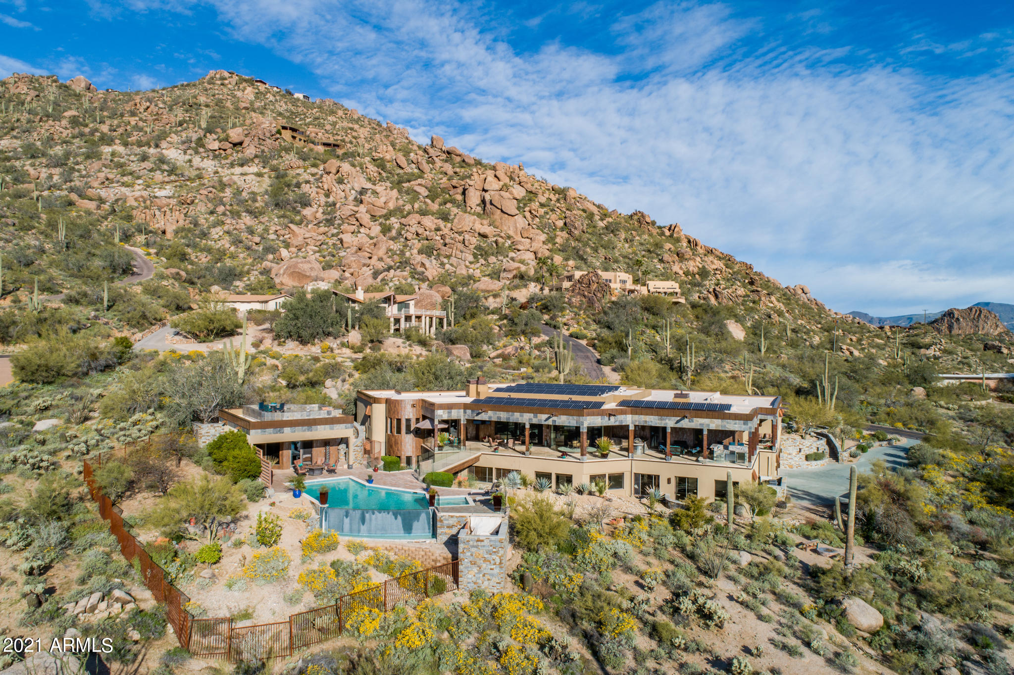 Arizona luxury living at it's finest. Situated on 1.64 acres of Black Mountain hillside this home is a true paradise. Bask in the different stunning views from every window - mountain, city lights, desert. Floor to ceiling, butted edge glass in the eat-in kitchen and wall of glass in the great room afford the ideal inside/outside Arizona living. Enjoy the gourmet kitchen with 48'' Wolf dual fuel range, Wolf microwave, 48'' Sub-Zero refrigerator/freezer & 2 Asko dishwashers. 2 Primary bedrooms (main level & basement), theater room with full kitchen, 1000+ bottle climate controlled wine room & tasting room, full gym. 300' of frameless glass enclose the full length covered patio and lead across the striking bridge to the negative edge pool, casita and view top deck. 2 garages with room for 9+ cars, lift & Tesla charging stations. Far enough from the rat race to feel secluded but close enough to enjoy fine dining and shopping on the regular. See features sheet for so much more!