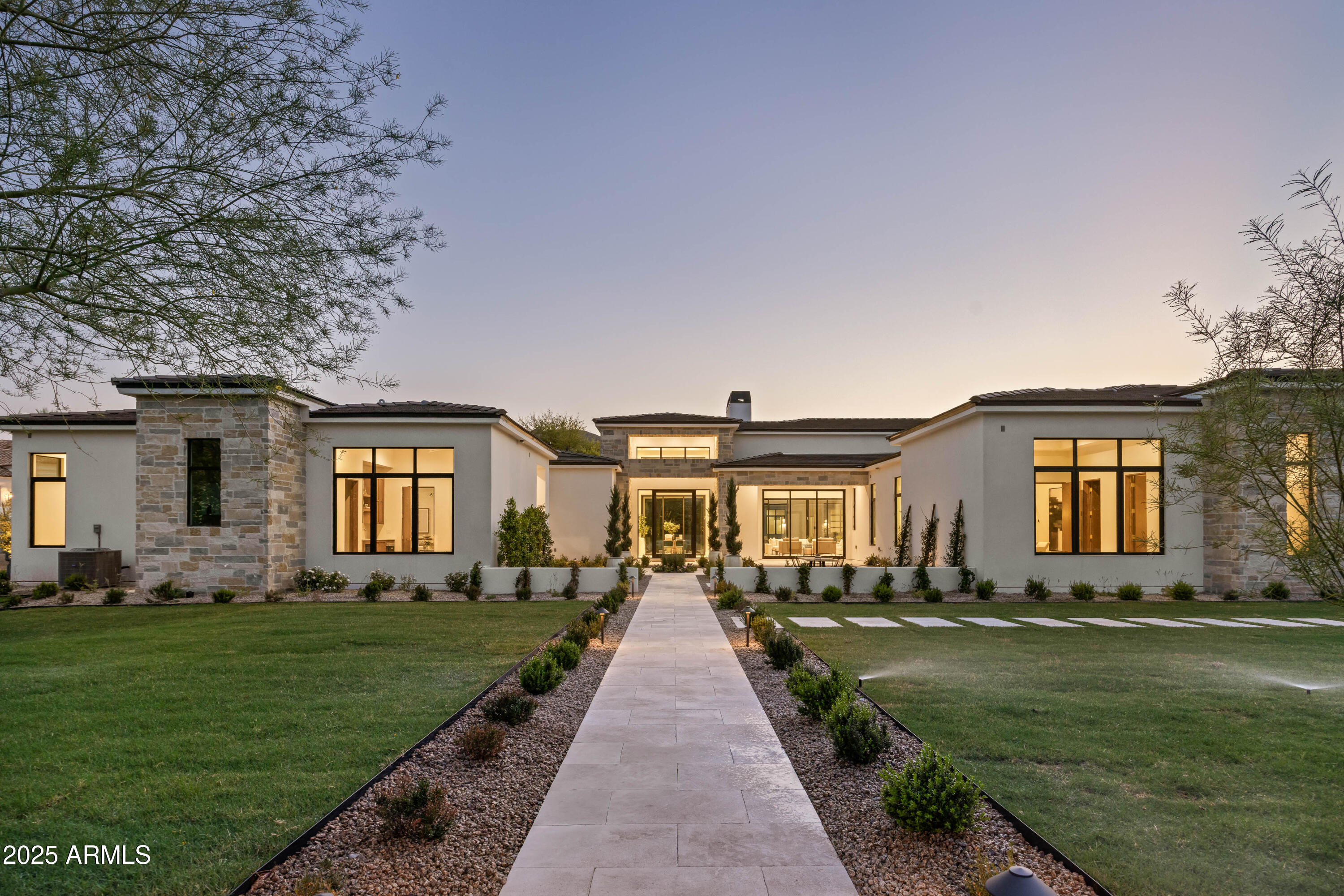 Stunning modern mediterranean estate blending luxury, functionality, and timeless elegance. Crafted by the renowned Travis Custom Homes, interiors by Kozi Designs, architect Ben Scheier of [i] PLAN and landscape architect Jeff Mandel.  Spanning 8,457 sq. ft. of total livable space, this single-story residence includes a 6,153 sq ft main house and a 2,304 sq. ft. private casita, offering unparalleled comfort and versatility. Designed for seamless indoor-outdoor living, the property features five en-suite bedrooms, a dedicated home gym with private bathroom, and a spacious casita with an en-suite bath.  Two additional half bathrooms, conveniently located in the main living areas, provide easy.. access for guests without disrupting private spaces, enhancing both hospitality and everyday convenience.

At the heart of the home, the expansive great room flows effortlessly into the formal dining area and a chef's kitchen, where top-tier appliances, custom cabinetry, and refined finishes set the stage for both intimate meals and large-scale entertaining. Oversized glass doors bathe the space in natural light and open to a meticulously designed backyard oasis, featuring lush ficus hedges, green trees, vibrant sod, and a state-of-the-art irrigation system.

The resort-style heated pool and spa provide the ultimate retreat, perfect for relaxation or entertaining beneath the Arizona sky. A 15 car + parking capacity, including spacious garages and additional slab parking, offers exceptional storage and convenience for car enthusiasts and guests alike.

This one of a kind estate by Travis Custom Homes is the pinnacle of modern Mediterranean luxury, designed for those who expect nothing but the best.