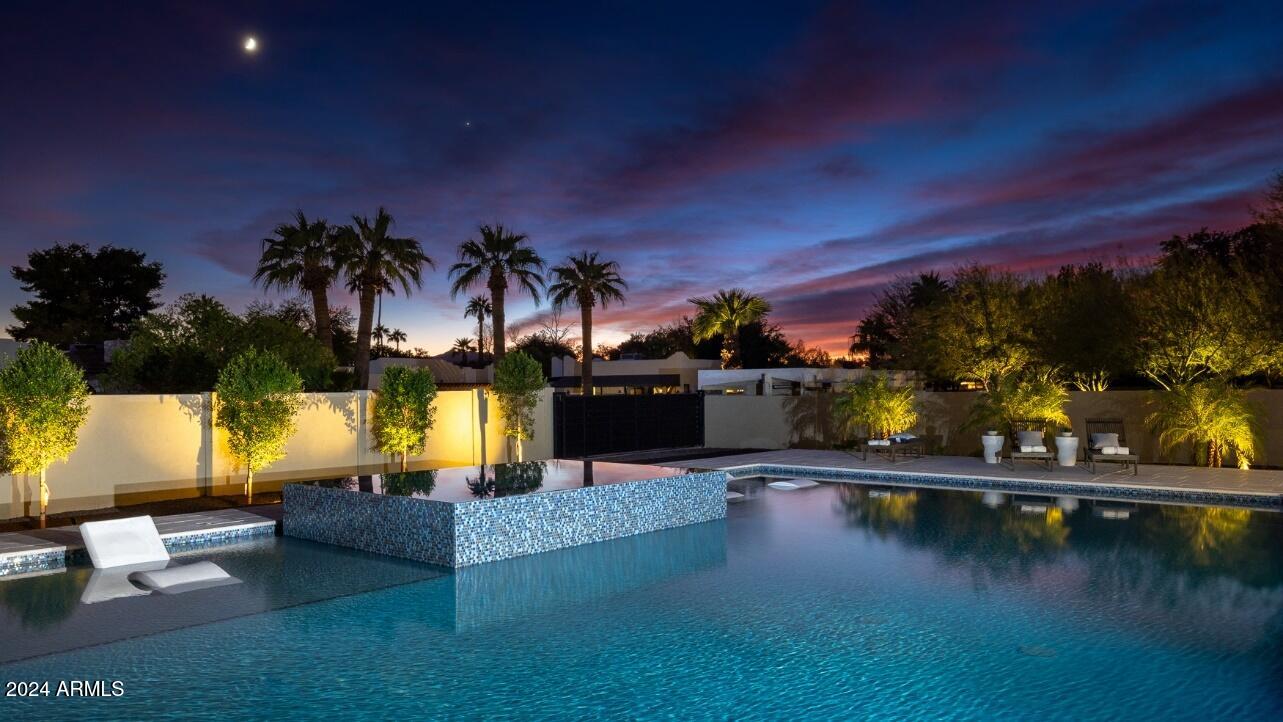 New construction in a quiet neighborhood just minutes from Scottsdale Quarter, Kierland, the new PV Mall, restaurants, the Mayo Clinic, great schools, Hwy 101 & more. Split floor plan w/4,278 sq ft on a half-acre, 4 ensuite bedrooms, 5 baths, office, bonus room, and a great room with soaring ceilings & a glass wall of retractable doors leading to an AZ backyard paradise w/a 4,500 sq ft bi-level patio surrounding a large negative edge pebble sheen pool & infinity spa!  Quality abounds w/black Andersen windows, Hinkley Lighting, 48'' Viking gas range, micro & dishwasher, a 66'' professional refrigerator, a large Taj Mahal Quartz waterfall island, European oak flooring, a concealed 14x7 ft butler's pantry & much more!  See the supplement below or docs tab for a detailed features list (Cont.) LUXURIOUS DESIGN
**	Spacious great room with soaring ceilings, clerestory windows and a glass wall of double, 8' tall tri-folding glass doors leading to the covered back patio and resort style backyard
**	Taj Mahal Quartz waterfall kitchen island with a large stainless galley sink, plenty of seating space and surrounding kitchen countertops with Montreal Quartz and an additional kitchen sink overlooking the exquisitely designed backyard 
**	Top-of-the-line stainless steel kitchen appliances, including a 48" Viking Dual Fuel Range with double ovens, 6 burners and a large griddle, a wall pot filler, a Viking microwave and dishwasher, a large 66" double door Professional Refrigerator and a built-in Thermador Espresso Machine
**	Glass wine cellar in the great room with gorgeous marble walls, a WhisperKool refrigeration system and built-in wine racks capable of displaying 147 or more bottles
**	A large 14 x 7 ft. concealed butler's pantry in the kitchen with a separate sink, refrigerator, icemaker and plenty of extra cabinet and food preparation space
**	Brizo and Delta faucets/fixtures throughout, two kitchen sinks, plus an additional sink in the hidden butler's pantry 
**	Wide plank White Oak flooring and 7" baseboards throughout
**	Large primary bath with a 14 x 7 ft. glass enclosed shower area with marble tile and a soaking tub, as well as two regular shower heads, two rainfall shower heads and two handheld shower heads 
**	Large primary walk-in closet with custom cabinetry, a chandelier and a full-length lighted dressing mirror 
**	Separate bar area just outside the primary suite with a quartz countertop, a wood paneled wall and beverage refrigerator 
**	4 additional bathrooms, all with custom floating Walnut finish cabinets, quartz counters, handcrafted Zellige tile and soft close drawers 
**	Fireplace with a 16 ft calming black tile surround/overmantel extending to the great room ceiling, currently exhibiting an 85 inch framed television, allowing you to exhibit art and/or accentuate your home design features when not viewing shows 
**	Fireplace overmantel is flanked on each side by hidden wall speakers, located just below the clerestory windows which brighten the room and highlight the towering great room ceiling
**	Large family room or media room adjoining the three west-wing bedrooms--a perfect play/relaxation area for the kids or guests 
**	Large laundry room with two washers and two dryers, thin edge shaker cabinets, quartz counter tops and a marble backsplash 

QUALITY CONSTRUCTION
**	All new 2024 construction incorporating a small slab from the prior home  
**	Smooth synthetic stucco exterior finishes with desert blended colors
**	All the modern touches, including 400-amp electrical service, numerous pre-wired functions, recessed LED lighting and stylishly unique Hinkley chandeliers
**	Andersen® energy efficient, low-E windows throughout and custom black steel doors w/Baldwin hardware 
**	Two Rinnai tankless gas water heaters with built-in recirculation pumps and smart phone monitoring capabilities
**	Entire home is spray foam insulated (energy efficient), including the garage, which also has an insulated garage door w/remote Internet operation capabilities.  The home's ceilings are rated R-30, and the walls are rated at R-19.
**	Home is pre-wired for sound, including connections for outdoor and landscape speakers, a home network, televisions, a surveillance system and motorized window shades, if desired
**	Two Trane R410A HVACs with programmable Nest thermostats

RESORT STYLE YARD
**	Taking center stage in the backyard is the heated, 46 x 30 ft negative edge pebble sheen pool and infinity spa with front bubblers, two Baja shelves, Microbrite multicolor LED lighting, a Pentair high performance heater, a Pentair cartridge filter, two energy efficient pool pumps, all surrounded and complimented by Miniature Pygmy Palms, accent plants and a large outdoor 4,500 square foot patio
**	The one-of-a-kind pool is surrounded by an equally stunning 4,500 square foot, two level, Artistic Stone outdoor paver patio, stretching from the back of the home and artfully surrounding the negative edge pebble pool and infinity edge spa.  This outdoor patio is truly an entertainer's paradise, and the beauty of the Artistic Stone pavers is matched by their utility, being comparatively cool to the touch even on the hottest days of summer! 
**	The outdoor patio includes a finished large steel ramada with a built-in BBQ (natural gas), ice cooler, TV, a fireplace and plenty of room for covered seating and/or lounge chairs
**	Perfect North/South home orientation with mountain views and covered front and back patios, both with tongue and groove ceilings and large side yards with the potential for additional parking, storage, and/or sport court
**	Spacious circular driveway made of Solar Gray pavers and an automated and remotely controlled backyard sliding gate, large enough for an RV
**	Professionally landscaped yard, including a front and back irrigation system, new sod, decorative rock, a Ficus privacy wall, palm trees surrounding the pool area, front yard desert landscaping including a large Saguaro, as well as other beautiful drought resistant desert plants