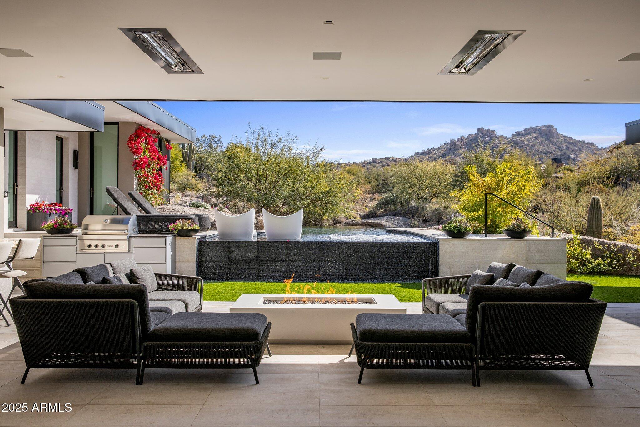 The award winning team of Salcito Custom Homes and Dale Gardon Design collaborated to create a modern masterpiece in Estancia * This architectural gem is sited on a dramatic lot with unique boulder outcroppings and has commanding views of Pinnacle Peak, creating a true desert oasis * Only the finest materials and finishes were chosen: Bulthaup cabinetry, white oak wood floors, marble slab surfaces, custom lighting, a multitude of Wolf & Sub Zero appliances, home automation system, and natural stone accents throughout * The modern floor plan is light and bright with a massive, open great room and floor-to-ceiling windows and pocket doors * Design details include a dedicated office, media room, elevator to the 2nd level suite, private/separate entrance casita, and an indoor/outdoor bar * The back patio is a seamless extension of the home with living and dining spaces, in-ceiling heaters, multiple fire features and TV * 3-car Garage with lift opportunities *