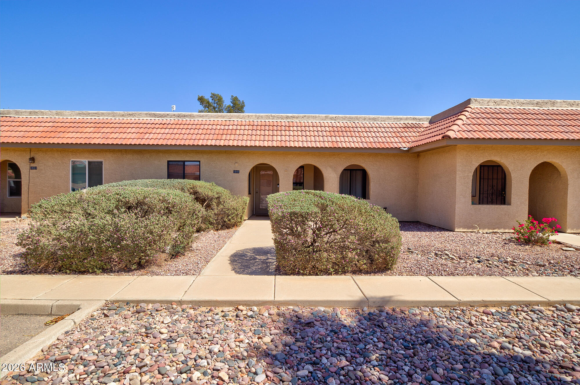 Welcome to your desert oasis in the serene Tierra Grande Country Club Community! This beautifully maintained home offers the perfect blend of comfort, style, and easy Arizona living. Relax on the spacious covered front patio or unwind in the open outdoor back patio that is perfect for entertaining or enjoying peaceful evenings outdoors.
Inside, the open-concept floor plan is enhanced by wood-look tile flooring and a warm neutral color palette throughout. The kitchen comes with all appliances--making it as functional as it is stylish.
The thoughtfully designed split floor plan features two spacious primary suites, each with its own ensuite and celiing fans in both bedrooms and the dining room.