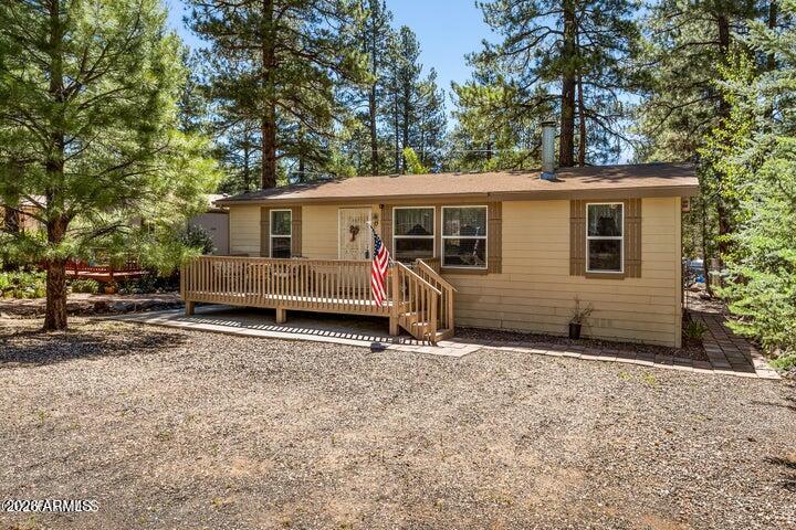 our perfect Munds Park escape awaits on a quiet cul-de-sac! This inviting split floor plan offers 3 bedrooms and 2 bathrooms, creating a comfortable layout for relaxing or hosting family and friends. The living area is complete with a cozy wood-burning fireplace and air conditioning for year round enjoyment. The spacious primary suite features an ensuite bathroom complete with dual vanities, while the guest bath offers a soothing soaking tub. Step outside to the fenced backyard with a large covered deck, an ideal space for entertaining, unwinding, or enjoying the crisp mountain!