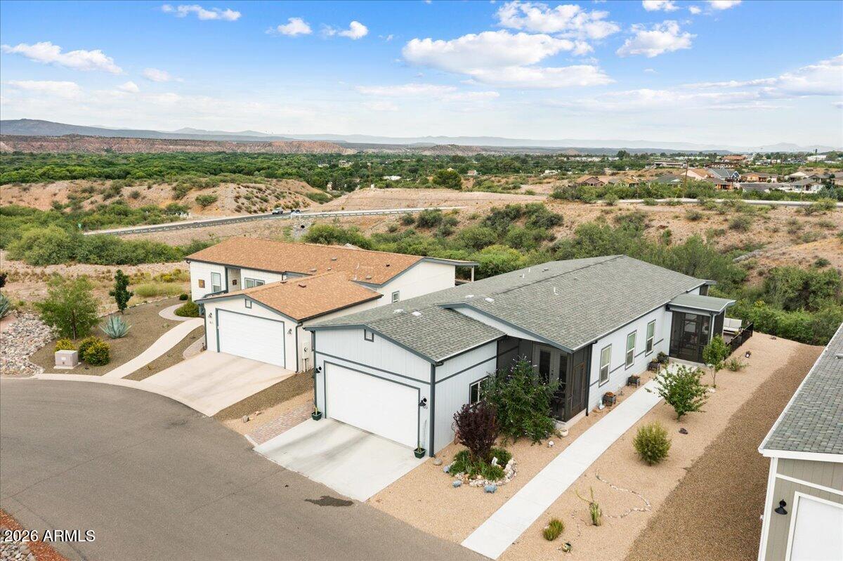 Refined Living in a Premier 55+ Community! Perched high above a private greenbelt on one of the largest and most desirable lots in the neighborhood, this exceptional home captures breathtaking panoramic and unobstructed Sedona Red Rock views while offering incredible privacy, tranquility, and an effortless resort-style lifestyle. Enjoy all the spectacular amenities this sought-after community has to offer, including championship golf, indoor heated pools and spa, yoga and fitness classes, a state-of-the-art fitness center, an on-site restaurant, and some of Arizona's finest dining just a short walk away.
Inside, you'll immediately appreciate the thoughtful design and quality throughout. The spacious floor plan offers two bedrooms, two baths, and a private den with French doors leading to its own screened porch--an ideal home office, reading room, or guest retreat. Soaring 9-foot ceilings, an elegant coffered ceiling, luxury wood-plank vinyl flooring, upgraded lighting, ceiling fans in every room, 5-inch baseboards, executive-height countertops, and oversized windows and transom windows fill the home with natural light.
The open great room and dining area are warm, inviting, and exceptionally bright with double sets of windows overlooking the Red Rock views. Three private screened porches create an amazing cross breeze throughout the home, making it comfortable year-round while blending indoor and outdoor living beautifully.
The gourmet kitchen was designed with both everyday living and entertaining in mind. Gorgeous 42-inch cabinetry with brushed nickel hardware features pull-out shelving throughout, beautifully complemented by easy-care Corian countertops and a timeless subway tile backsplash. A deep sink is perfectly positioned beneath a window, bringing in natural light while you prepare meals. The built-in microwave and wall oven, electric cooktop, upgraded stainless Frigidaire appliances, reverse osmosis system, and enormous walk-in pantry make this kitchen as functional as it is beautiful. The oversized center island--designed without a sink--offers an uninterrupted workspace every chef will appreciate, along with abundant cabinets and pull-out storage.
The spacious primary suite is a peaceful retreat featuring a large walk-in closet and a sliding barn door leading into the luxurious ensuite bath. Enjoy executive-height dual vanities, a large linen closet, abundant natural light from an oversized window, a beautifully tiled walk-in shower with bypass glass enclosure, and new rain shower heads that create a true spa-like experience. The guest bath has also been updated with a new rain shower head.
Storage and functionality continue throughout the home with extra hallway linen cubbies and an oversized laundry room featuring 42-inch upper cabinets, a generous folding counter, hanging space, executive-height countertop, a large window, and newer LG washer and dryer that convey.
The garage is equally impressive with an elevated ceiling, 8-foot garage door, keypad entry, and plenty of room for storage.
Outdoor living is where this home truly shines. In addition to the private screened porch off the den, you'll enjoy a screened front porch and an enormous screened back porch spanning the full width of the home--perfect for relaxing, entertaining, or simply taking in the spectacular Red Rock and Mingus Mountain views. The fully fenced paver side yard offers additional private outdoor space, while the beautifully landscaped front yard is accented with butterfly bushes, apricot and pear trees, and Arizona Juniper that add charm, color, and wonderful curb appeal.
Additional upgrades include a whole-house saltwater softener, reverse osmosis drinking water system, 2-inch blinds throughout, and numerous thoughtful details that make everyday living comfortable and convenient.
This is far more than a beautiful home--it's an exceptional opportunity to enjoy luxury, privacy, spectacular views, and an active lifestyle in one of the area's premier 55+ communities.  But HURRY, at this price, it won't last long!!!
