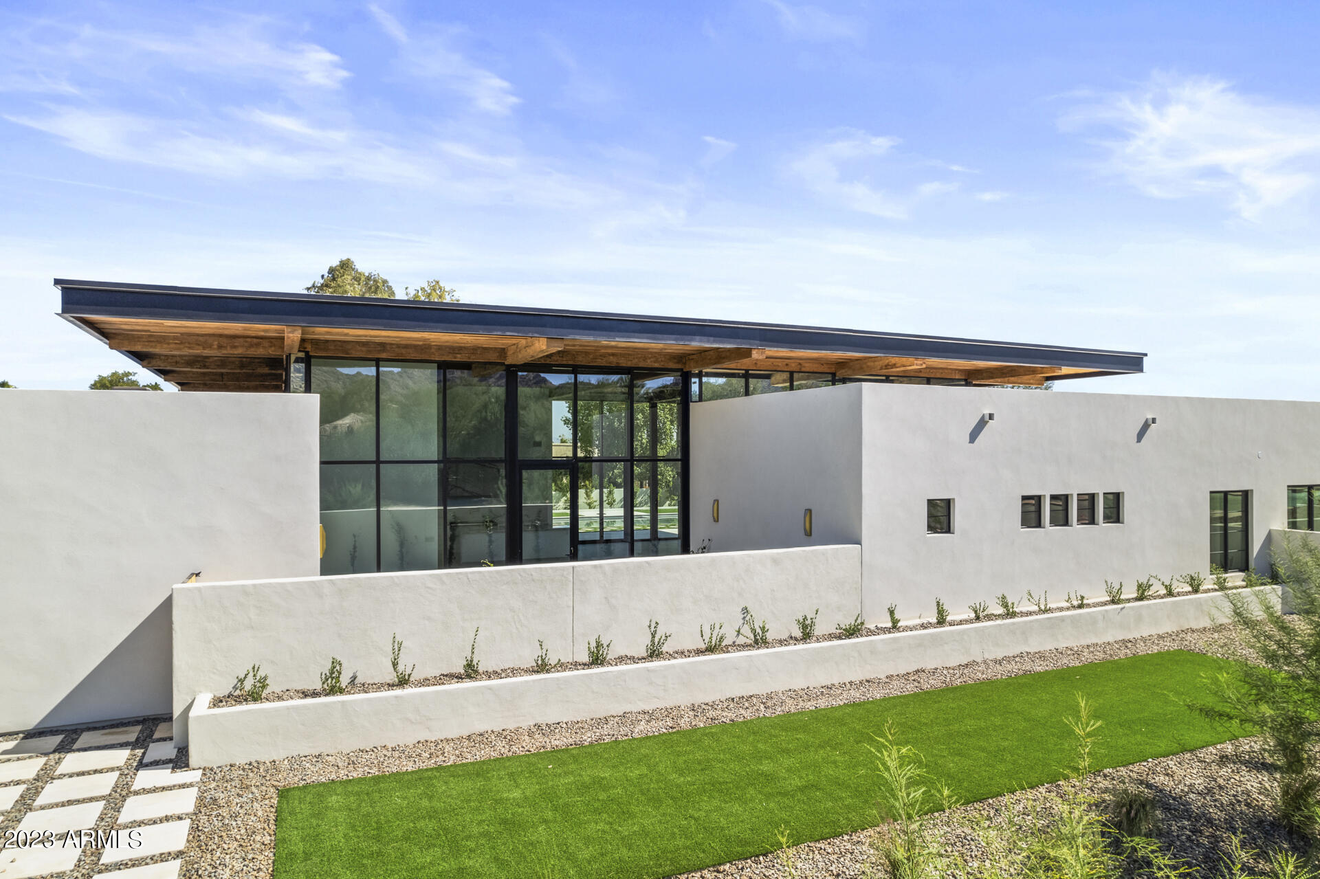 Paradise Valley has a beautiful new custom home build available just a few streets North of the Ritz-Carlton and Palmeraie Developments! This design is the perfect combination of modern and classy with some incredibly unique rustic touches. Sitting on an acre+ lot, the great room is surrounded by floor to ceiling windows/doors, making for indoor/outdoor living perfection. At 5,560 square feet, this epic build features 5 bedrooms, an office, flex/game room and 6 baths. The 18-foot ceilings in the great room create a grand entrance and living experience with stunning views to both the private front courtyard and the resort-like backyard. Exquisite custom cabinetry, Carrera stone marble fireplace, a large butler's pantry featuring custom glass/brass shelving, and Sub-Zero/Thermador/Wolf appliances create the ultimate entertainer's lineup. With Newport brass faucets, Shaw and Allia Sinks, Tilda chandeliers, Lutron shades, Farrow and Ball/Benjamin Moore paint, C-4 lighting and speakers scenes, this home leaves little to desire. A luxurious master suite brings all the amenities including a fireplace, sitting area, Kallista Papion cast stone tub, oversized shower, and custom built vanities and closet. The remaining bedrooms, separated from the master, each feature en-suites and walk-in closet spaces. The office stands alone with floor to ceiling 360 degree millwork. Walk through your oversized mudroom with a custom drop zone as you enter from the oversized four-car garage (6 tandem). And finally the flex/game room features Ann Sacks wall tile paired again with a wall of windows/doors that bring connectivity to the next level! Outside prepare to be overwhelmed by massive patios, surrounded by imported Italian marble hardscapes, Coyote outdoor accessories, steel border package, desert adapted low maintenance plants, misting system, professional grade artificial turf, and a temp controlled pool and spa. With views of Camelback and Mummy Mountain and plenty of options to add, don't miss the opportunity to call this your next home.