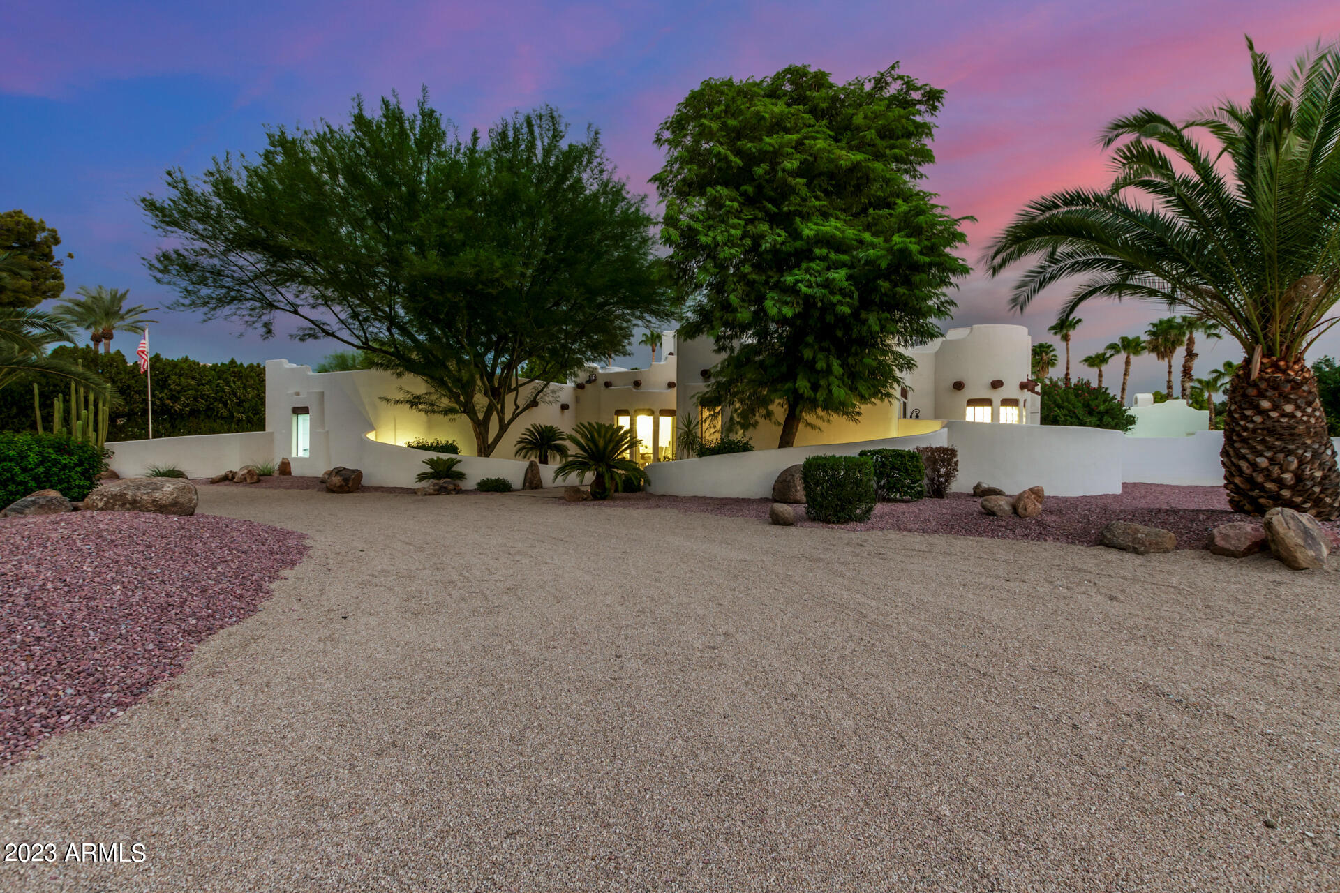 Just WOW! Welcome to a residence where sophistication meets desert elegance. Greeted by a graceful circular drive, this home boasts a striking facade complemented by a 3-car garage, convenient RV gate, and a meticulously curated desert landscape. Enter the living room that envelops you with its grandeur. Soaring ceilings featuring exposed beams that elevate the space creating an open yet intimate atmosphere. Entertain guests with a drink at the strategically placed wet bar while abundant natural light cascades in, accentuating the contemporary wood-look flooring. The formal dining room provides an elegant space for memorable meals and gatherings. Fabulous yard featuring bocce court, bar b que, firepit,lush landscaping,  citrus, sparkling pool & spa and casita for total privacy..... The kitchen is a culinary masterpiece, equipped with a cozy breakfast nook, quartz countertops, and a matching backsplash, gleaming under the skylights and recessed lighting. SS appliances, timeless shaker cabinets adorned with crown moulding, and a central island make meal prep a delight. The added pantry ensures ample storage, and a peninsula with a breakfast bar provides a hub for casual dining. The main bedroom offers direct backyard access and brings nature close, while the ambient glow from the two-way fireplace adds a touch of romance. The en-suite bathroom, a spa-like retreat, features dual vanities and a spacious walk-in closet to satisfy all your storage needs. Venture outdoors to the vast backyard, a true entertainer's paradise. A covered patio beckons for alfresco dining, leading to a comprehensive outdoor kitchen. Gather around the fire pit on chilly nights, or dive into the sparkling pool during warmer days. The pristine lawn is an oasis of green, while a separate guest house ensures privacy for visitors. After a long day, immerse yourself in the calming spa, letting its therapeutic waters soothe you. A gem like this is a rare find! Make it yours before it's gone!