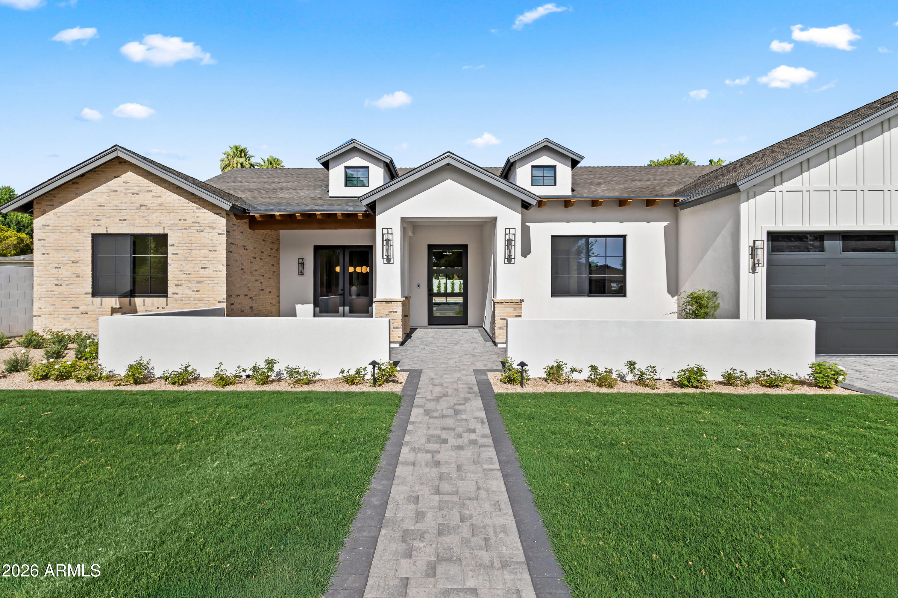 Stunning new construction in the heart of Arcadia Osborn! Just completed and spanning 4,659 square feet, the home features 5 bedrooms, 5 full bathrooms, and 2 half bathrooms within a thoughtfully designed split floor plan. Step inside to expansive open-concept living spaces highlighted by vaulted ceilings with exposed wood beams, wide-plank white oak flooring, custom built-ins, a gas fireplace, and a dramatic wall of sliding glass doors that seamlessly connects indoor and outdoor living. Designed for effortless entertaining, the home features a formal dining room and a chef's kitchen complete with an oversized island, Sub-Zero appliances, breakfast nook, dedicated coffee bar, walk-in pantry, and fully equipped back prep kitchen with sink, wine fridge, and Wolf built-in coffee system. The luxurious primary suite serves as a private retreat with direct backyard access, dual vanities, a soaking tub, oversized walk-in shower, and a custom walk-in closet. A versatile bonus flex room offers endless possibilities as a game room, media room, playroom, or home office. The resort-style backyard is designed for year-round enjoyment with a heated custom pool and spa, built-in BBQ station, covered patio, and professionally landscaped front and back yards. Additional features include a spacious 3-car garage, 4 en-suite bedrooms, and front porch. Ideally located near Arcadia's most popular restaurants, boutique shopping, premier golf courses, and Arizona's finest luxury resorts, this home offers the very best of Arcadia living.