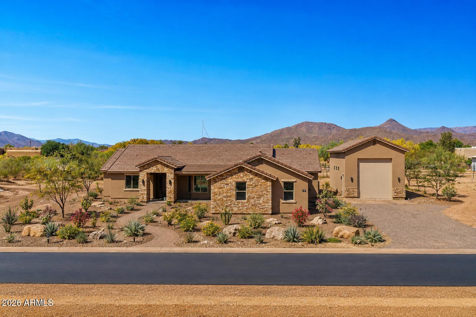 JUST COMPLETED brand new custom home featuring jaw-dropping finishes and a MASSIVE detached 20 X 50 RV garage. Perched on a 1-acre lot with full block fencing, full front yard landscaping, no HOA, and breathtaking views of Cave Creek Peak and Pyramid Peak, this property truly stands apart. Inside, the gourmet kitchen impresses with upgraded cabinetry, quartz countertops, a massive center island, and a walk-in pantry. The spacious great room showcases a dramatic sliding glass door that opens to the outdoors and a beautiful chandelier centerpiece. Luxury continues throughout the home with wide-plank wood like tile flooring, a freestanding soaking tub in the owner's suite, and so much more! Front yard landscaping is included, and will be installed by June 12th.