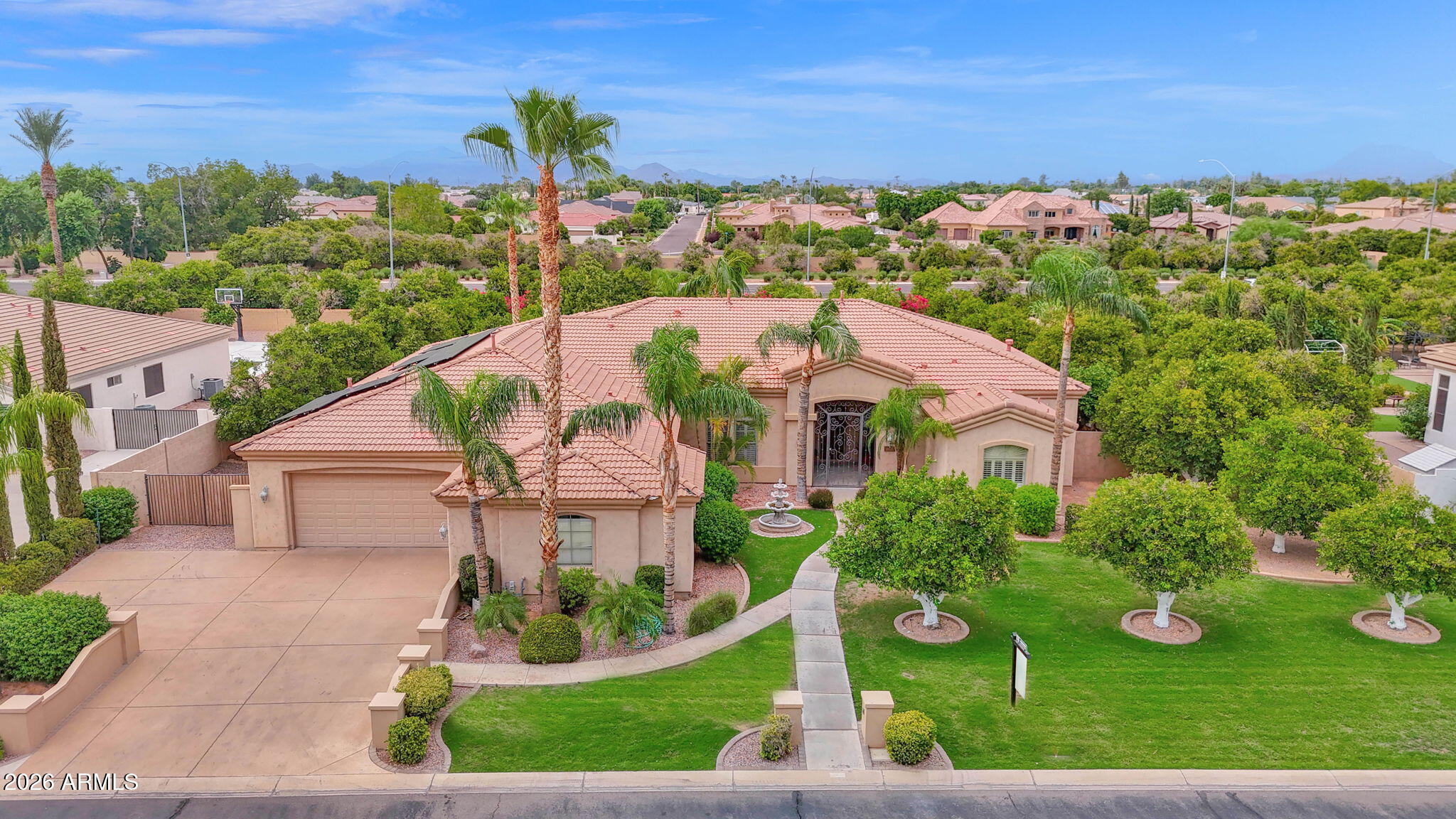 Discover the epitome of luxury living in the prestigious gated community of Arboleda. This exquisite 4 bedroom, 3.5 bathroom, single level, semi custom home is perfectly situated on a sprawling 8/10 acre plus lot, offering both privacy and elegance. Designed with a thoughtful split floor plan, this residence caters to both comfort and sophistication. The gourmet kitchen is a chef's dream, featuring custom cabinets, double ovens, Bosch dishwasher, granite countertops, and a cozy eat in kitchen. Large walk in pantry. The family room with 12 foot ceilings, warmed by a gas fireplace, provides a welcoming space for relaxation and gatherings.Formal occasions are well accommodated in the combined living and dining rooms, 12 foot ceilings that enhance the home's spacious feel. Flooring throughout is a tasteful mix of natural stone and new carpet, laying the foundation for your personal decor. The primary suite is a true retreat, stretching from the front to the back of the house with two walk in closets. The primary bathroom features a soaker tub and a large shower for ultimate relaxation. The split floor plan has one en suite bedroom and two other bedrooms with a full bathroom. An additional bonus room offers flexibility for your lifestyle needs. Private office. Crown molding and natural stone baseboards. 3 car garage. Outdoor living is equally impressive. An outdoor oasis includes built-in gas BBQ, fire pit, sparkling pool with waterfall, grotto, child's play shelf and spa. Backyard includes multiple mature citrus trees (grapefruit, orange, and lemon) all maintained with low-cost flood irrigation. Dual covered patios provide a shaded space for outdoor dining and leisure. Ample storage throughout the home adds to the convenience and appeal of this remarkable property. Save on energy bills with leased solar. Located close to the 202 freeway, residents enjoy easy access to all parts of the Phoenix metro area, including PHX Sky Harbor. With top-rated schools and beautiful parks nearby, including the Mesa Tennis & Pickleball Center at Gene Autry Park, big league dreams, and Kensington Groves Park, this home is not just a residence but a lifestyle choice for those seeking the best in Mesa living.
