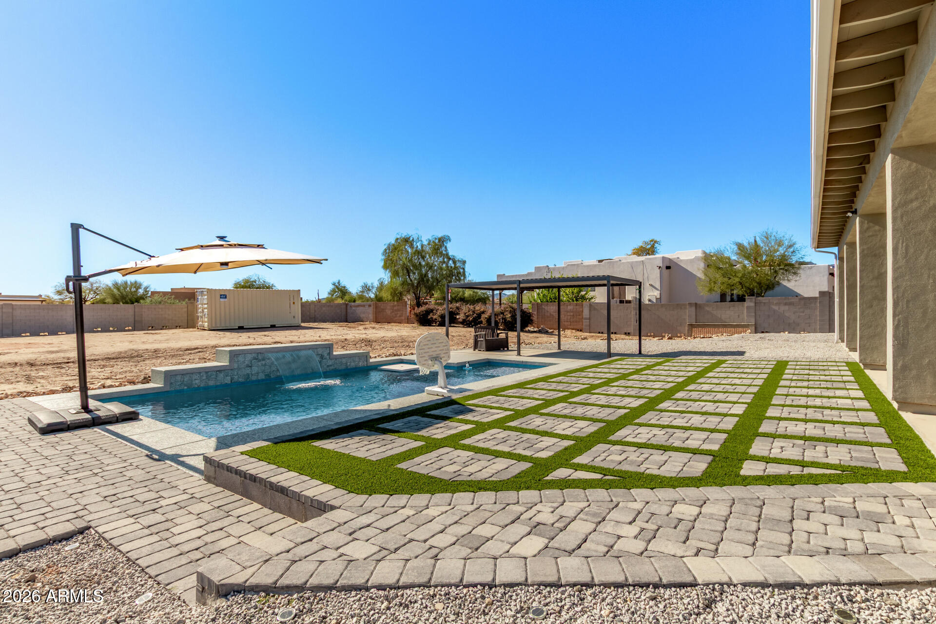 Beautifully located home just minutes from the highly desirable Verrado area. Enjoy convenient access to a growing selection of shopping and dining options, including Costco, Target, and many more retailers coming soon. This location offers both comfort and future value as the community continues to expand.  This spacious 5-bedroom horse property offers a 3-car garage, RV gates, and charming stone accents. Inside, enjoy high ceilings, recessed lighting, and elegant wood-look flooring. The bright great room opens to a stunning kitchen with quartz counters, white shaker cabinets, pendant lighting, stainless steel appliances, and a large island. The luxurious primary suite features backyard access and a spa-style ensuite with a soaking tub. The sprawling backyard is a true highlight, featuring breathtaking mountain views, a full-length covered patio for dining al fresco, well-laid pavers, a lovely gazebo, pristine artificial turf, & a sparkling pool for refreshing dips. This gem is an incredible find!