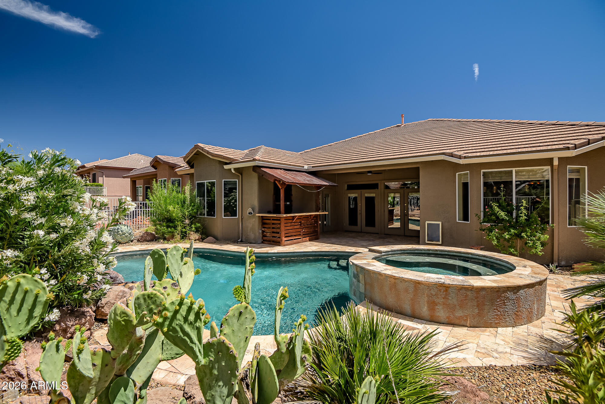 Located in the gated Amante neighborhood within Verde Santa Fe, this beautifully refreshed home offers easy living with stunning Mingus Mountain views at the end of a quiet cul-de-sac. Featuring new interior and exterior paint, stained concrete floors throughout, and an open-concept layout centered around a spacious kitchen with butcher block island. Three sets of French doors open to a resort-style backyard complete with a custom pool, hot tub, water feature, outdoor bar, and expansive patio designed for entertaining. Residents enjoy access to the private Amante clubhouse with a heated pool, spa, fitness room, and social spaces, and pickle-ball court.