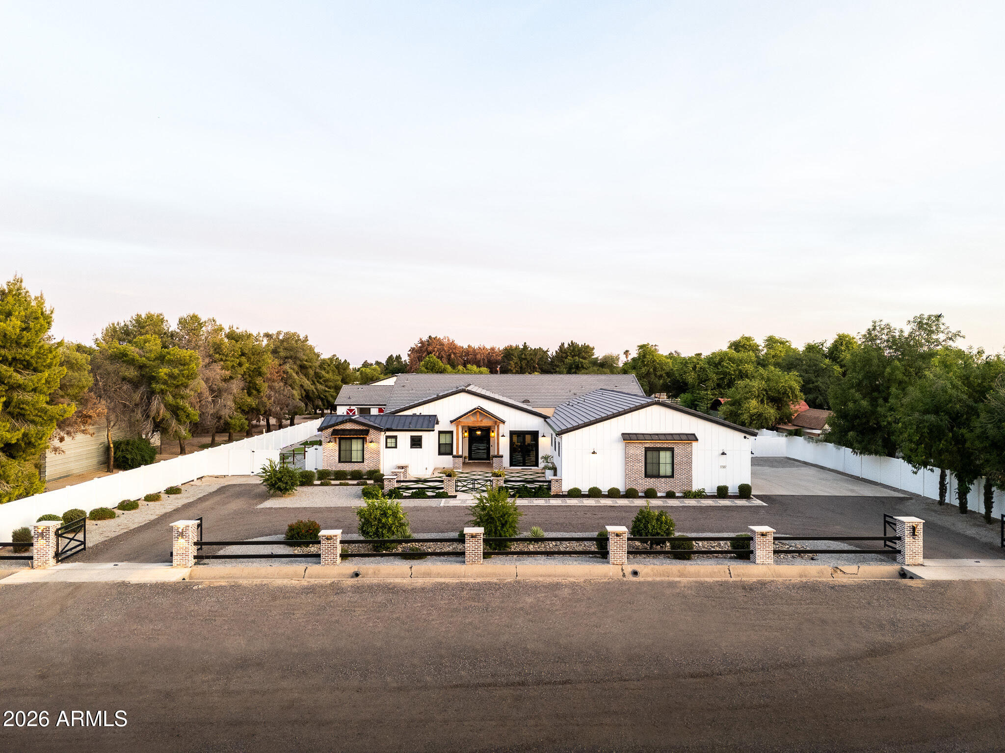 One-of-a-kind stunning modern farmhouse estate situated on 1.38 acres with breathtaking White Tank Mountain views. Built in 2023, this fully custom compound offers over 6,000 livable square feet including a detached guest house, oversized RV garage, and resort style amenities.
Designed for both luxury living and entertaining, the property features a custom pool, putting
green, pickleball court, outdoor BBQ, rooftop deck, covered patios, and multiple RV gates with
ample room for toys and trailers. The main residence includes a theatre room, gym, office, hidden butler's pantry, coffered ceilings, commercial grade appliances, and premium designer finishes. Rare opportunity to own one of the West Valley's most unique luxury farmhouse compounds located directly across from Sterling Grove.