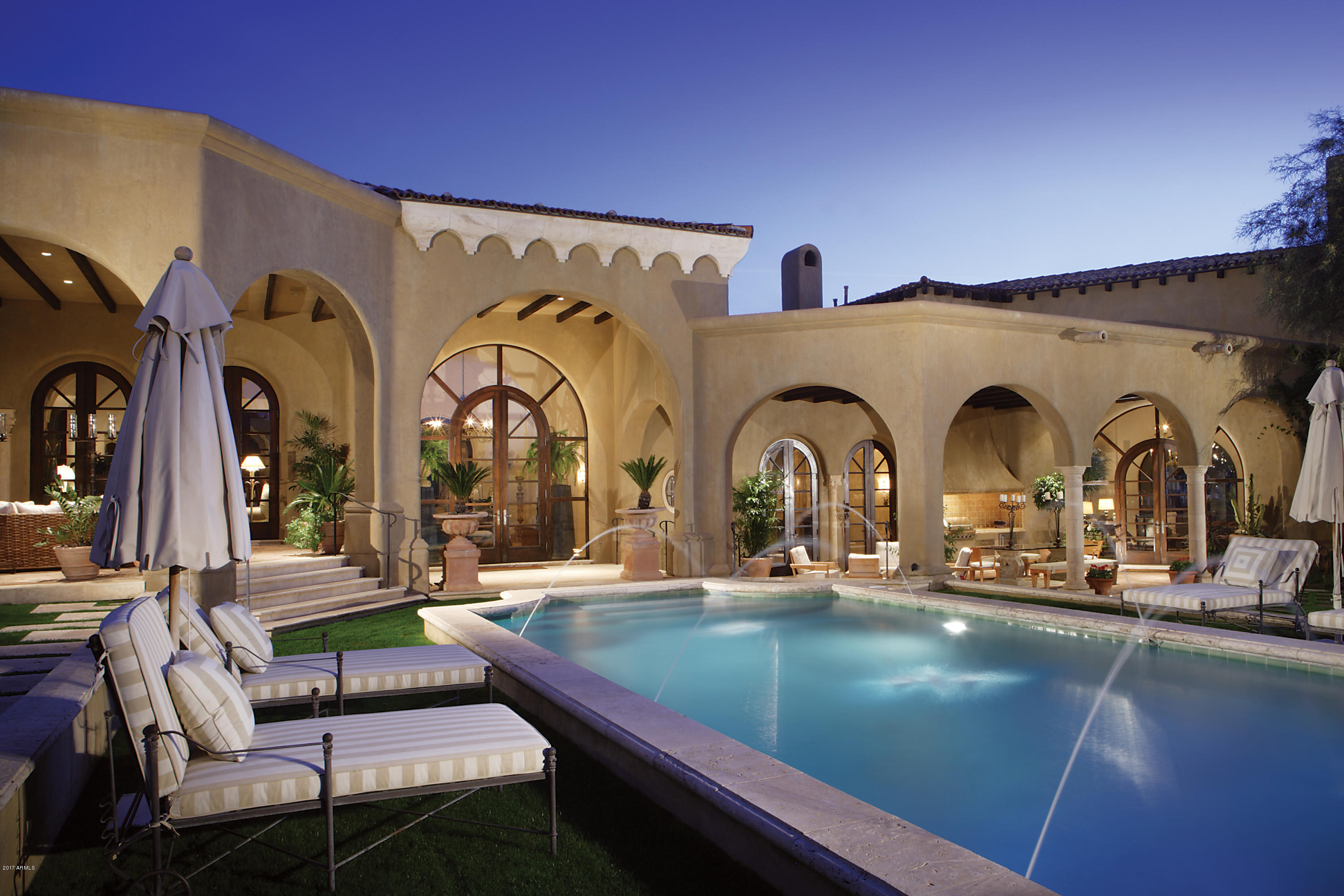 Nestled among the natural desert landscape of North Scottsdale, a rare opportunity awaits. A uniquely designed estate inspired by Wallace Neff . This Spanish Revival property captures the soul and spirit of the most prestigious homes built during California’s golden age. Ideally located in the sought after community of Desert Highlands, this timeless home is perched on three acres of  privacy.  Built by renowned builder Nance Construction the interiors include, intricate Portuguese limestone and ebony walnut flooring, hand plastered walls, soaring ceilings with elaborate wood beams and custom iron work by Peter Sevin. Artfully designed, the library includes lightened Georgia Sugar Pine Millwork that also serves as a convenient screening room, the carved detail is truly a vision to behold. The two story kitchen is astonishing with soap stone countertops, a large butcher block island, and a professional stainless steel appliance package, including a glass door Traulsen refrigerator and freezer, Thermador indoor grill, and a one of kind La Cornue French stove. The second floor of this manor has its own private entrances and showcases an additional laundry room, two oversized bedrooms, two luxurious baths, as well as an intimate second story patio. The breathtaking master suite has rich wood flooring, a large stone fireplace and hand crafted French doors that lead to a private patio and spa. The glorious master bath showcases marble top vanities, upholstered walls, his and her boutique style closets, hand-cut marble flooring and a deep free standing soaking tub. Mirroring the intricate details in the main home, the guest casita features an intimate kitchen with a Gaggeneu cooktop, a spacious bedroom, laundry room, and a luxurious bathroom. The grounds of this private estate are a glimpse into a timeless paradise. Designed by Santa Barbara Landscape Architect; Puck Erickson, spectacular archways line the grand sitting area that feature an outdoor fireplace, rose garden, and built-in barbecue. The mosaic tiled pool's dazzling waters lead up to a poolside cabana with wet bar and picturesque views of Pinnacle Peak. This magnificent property with star quality in the desert is simply awe-inspiring!
