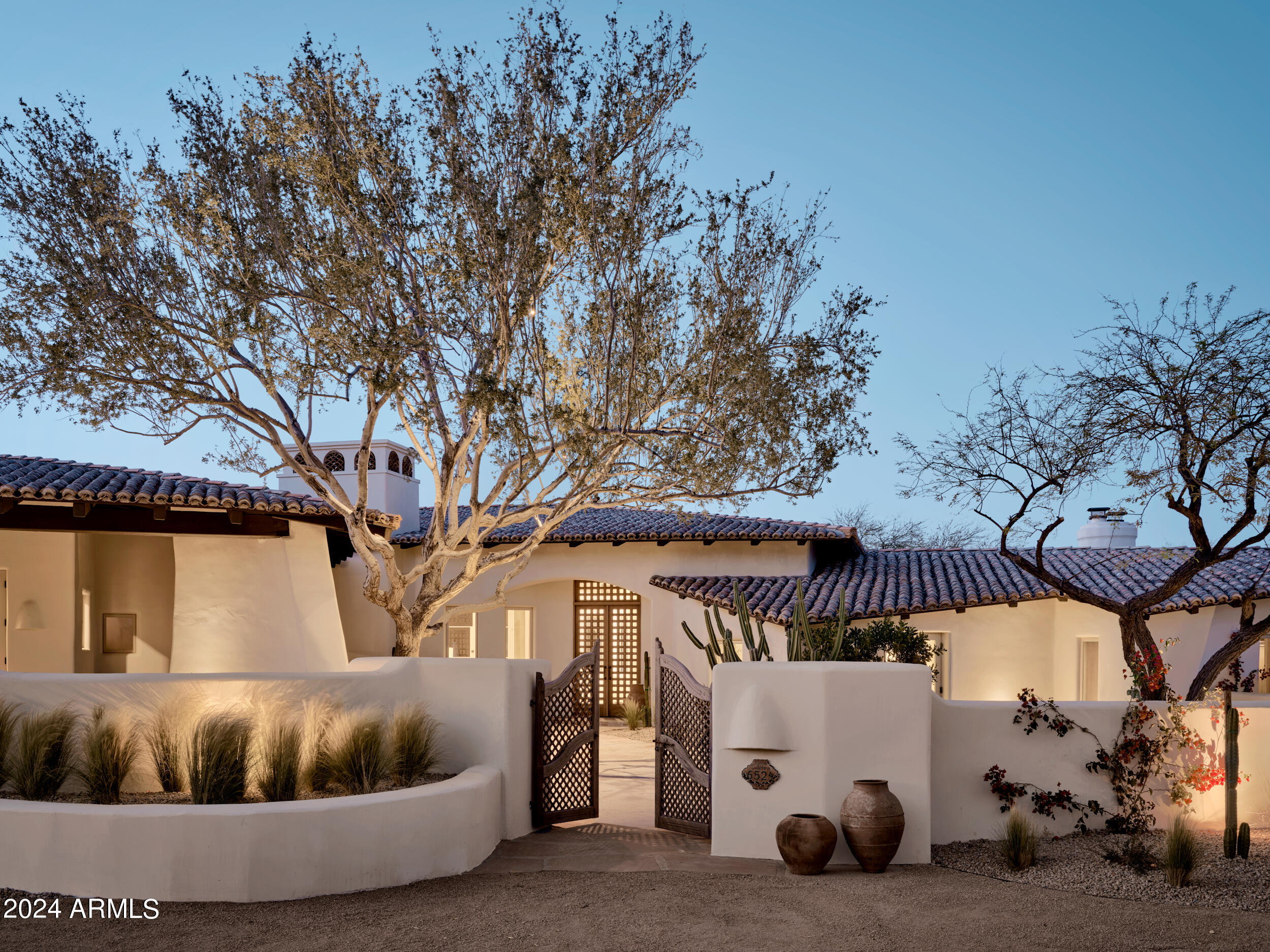 Introducing Santa Fe Hacienda, an exquisitely restored and reimagined Nance masterpiece by Modern Nest situated on a generous 1-acre lot in the heart of Paradise Valley. This stunning residence showcases a captivating blend of Santa Fe-style design with luxurious modern and rustic accents throughout its expansive 5466 square feet and its 4 bedrooms and 6 bathrooms. Boasting an impressive main living area adorned with an oversized gas fireplace, two comfortable sitting areas, and a handcrafted wet bar with a limestone sink, and walk-in wine cellar, this home offers an unparalleled setting for both relaxation and entertainment. The elevated chef's kitchen is a true culinary haven, featuring reclaimed terracotta flooring, hand-hewn wood ceiling beams, impeccably designed cabinetry, high-end lighting fixtures, and top-of-the-line Wolf and Sub Zero appliances. The butler's pantry, just off the kitchen, offers additional storage paired with charming design and function. Adjacent to the kitchen, an elegant dining space awaits, complemented by picturesque windows that flood the room with natural light. The owners suite is a sanctuary unto itself, with a cozy fireplace, a private patio retreat, and an office with its own outdoor patio. The bath is a spa-like oasis, complete with a freestanding copper bathtub nestled near another fireplace, separate vanity areas, and a luxurious shower experience. The oversized closet is a masterpiece of design, featuring custom cabinetry, abundant storage, and ample natural light. A spacious media room, equipped with a convenient kitchenette, provides the perfect spot for casual gatherings and relaxation, while three additional bedrooms offer comfort and privacy, each with its own ensuite bath and outdoor patio access. The functional yet stunningly designed mudroom/laundry room boasts dual washers and dryers, abundant cabinetry, and a convenient drop zone, ensuring effortless organization and convenience. Outside, the sprawling backyard beckons with expansive patio spaces, an outdoor kitchen with a pizza oven and fireplace, and a newly rebuilt pool surrounded by lush landscaping and high-end lighting and sound systems. This home epitomizes elevated living, seamlessly blending authenticity with modern luxury. An absolute must-see to fully appreciate its exceptional offerings.