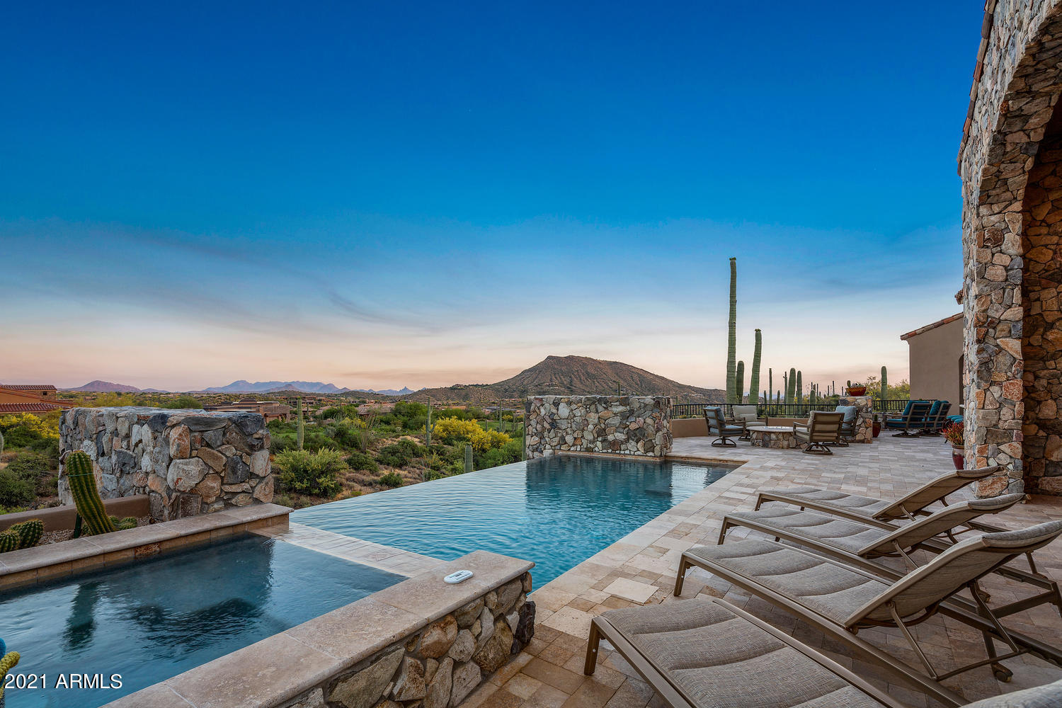 Welcome to Saguaro Forest 108, an elegant, 5,533 square-foot, Great Room floor plan, custom home with no interior steps and golf course and panoramic mountain views.  It is located in Desert Mountain, a fabulous 8,200-acre recreational development in north Scottsdale, AZ.  The ''Saguaro Forest'' is one of about forty-five different ''Villages'' in Desert Mountain and is widely considered to be one of the most prestigious places to live within the community.  

The home has a total of four bedrooms, one of which is part of a three-room guest area, essentially a ''casita inside the home'' (the bedroom; a small, full kitchen; and a living room) that has direct access to one of the two two-car garages.  This casita can be locked off from the rest of the home if desired.  Two other bedrooms adjoin the casita on that side of the home.  The middle bedroom is ensuite with an outside door allowing access to the pool patio.  The front bedroom on that side opens onto a semi-private patio, part of the very spacious rear pool, spa, firepit, and outdoor kitchen patio.  A shower bath in the hall outside this front bedroom serves the bedroom and doubles as the pool bath.  


The master suite on the other side of the home is special.  The bedroom is large and has a big fireplace in it with hand-carved stone fireplace surrounds. You can turn the fireplace on and off with a wall switch which makes it easy to use and enjoy.  The master bathroom has a huge soaking tub in it, double water closets, and two separate dressing rooms, separated by a large, walk through shower with three shower heads.  
 

The home is of Tuscan-styled architecture with lots of stone on the exterior but is atypically light and bright on the inside with near-white walls.  It is on a private, southeast-facing, 44,756 square foot homesite, overlooking the tenth tee box of the Chiricahua golf course (one of seven golf courses in Desert Mountain).  The southeast solar exposure is perfect in that it allows for lots of sun on the pool patio until late in the afternoon, but shade when the sun is low in the sky, making the back patio very useful as a place to relax without having to fight the setting sun every night, colorful sunset or not.  The home sits above and behind the Championship tee box (very rarely used) at a distance of about sixty yards, with the Regular tee box being about 115 yards away, so there is no risk of getting hit by golf balls and golfers are not so close as to be disruptive to a quiet book reading session by the pool.  The cart path is on the other side of the tee box, which is ideal for a golf course home (keeps the cart traffic a little further away).  The views beyond the golf course include nearby Lone Mountain, and the McDowell Mountain range about seven miles distant.  It is a great view and a very nice setting.  


Other details include a second two-car garage (both have epoxy coating on the floor), no interior steps once inside the home, a generously sized auto courtyard in front of the home, a "bonus" room that could be used as an office or a media room (its current use), a "top of the line" collection of kitchen appliances and space for a chef to spread out and do great work, a large walk-in pantry, a casual dining area that catches a lot of morning sun next to the kitchen with outdoor patio access, a formal dining room with a beautiful crystal chandelier, a superb laundry room, and a "Lounge".  The Lounge has a walk-behind wet bar, with a temperature-controlled wine storage room behind it (without a racking system, affording a new owner complete control of what goes into the room for wine bottle storage purposes), and a fine decorative glass and iron door.  The wet bar has a counter with room for four bar stools. Aside from the bar stools, the room is big enough for a couple of other seating areas.  A two-way, large fireplace set in a free-standing, floor-to-ceiling fireplace column separates the Lounge from the Great Room.  


The Great Room is the focal point of the home, with large sliding doors that open onto a covered outdoor living room on the back patio, easily large enough for a full-sized sofa, two side chairs and a coffee table in the middle.  The back patio keeps going and going, with lots of room for chaise lounges and plenty of seating around a stand-alone firepit.  This firepit is next to the outdoor kitchen, which has a large counter and room for four bar stools around it.  For you readers thinking Arizona is too hot in the summer to enjoy year 'round living, this home is at an elevation of about 2,900', making for a fabulous climate twelve-months of the year, given the lack of humidity and the way the desert loses its heat when the sun goes down in the summer.  


All in all, this is a terrific opportunity to own a lovely, "right-sized", relatively new home, with fine appointments, in a very desirable location, in one of the great developments in the United States.  


More on Desert Mountain...  It is a highly acclaimed, thirty-two-year-old, 8,200 acre, gated, private golf and outdoor recreation-oriented master planned development on the slopes of the Continental Mountain range, contiguous to the fourth largest National Forest in the country. There is a twenty-mile private trail system in these mountains for the exclusive use of Desert Mountain residents.   The top elevation is 4,890', highest in all of Maricopa County.  The views from the high point in the trail system are really something to see!  Phoenix Sky Harbor Airport is typically about a forty-minute drive from the community's Front Gate.  The opportunity to be a member of the community's private club, The Desert Mountain Club, is a significant part of the attraction of living in Desert Mountain for most property owners. The Club is the emotional, physical, and social "core" of the place. Membership is not included in the purchase price of the home but is available from the Seller on a separate basis after being approved by the Club.  The Club is rightfully internationally famous as a year 'round, private spa and golf mecca, with seven clubhouses, nine dining venues, six eighteen-hole championship Jack Nicklaus Signature courses, four practice ranges, a high-tech golf performance center, and, an eighteen-hole par-3 course, rated for handicap purposes.  That course, known as "Seven", has a "sports bar" clubhouse with twenty-eight big screen televisions, two bocce ball courts, and several huge firepits.  It opened in the Spring of 2019 and was hugely welcomed by the Club's membership.  


One of the other Clubhouses is the Sonoran Clubhouse, a truly amazing swim (three pools), tennis (nine courts, including one grass, five Har-Tru, and three cushioned surface hard courts), fitness, spa facility with a grill restaurant.  It enjoyed a $12,000,000 renovation in 2016. The following summer saw six pickleball courts, two bocce ball courts, and a croquet court added. It is now perhaps the premier facility of its type in the entire Southwest.


The Club's dining venues offer a wide variety of food, wine, and atmospheres. No coats and ties required! A tremendous range of non-golf outdoor recreation and social activities are also available. The Club's membership is catered to relentlessly by an attentive Club staff and Concierge, providing unparalleled service. In a word, the place is "phenomenal". It is so good, three multi-million-dollar lottery winners have chosen Desert Mountain over the years as the place they want to live.


Desert Mountain is a place of surpassing scenic beauty with long-range, panoramic views of Phoenix, Scottsdale, the entire "Valley of the Sun", many mountain ranges near and far, and, of course, Arizona's famous sunrises and sunsets! It now has about 1,900 finished homes ranging in size from 1,800 to over 20,000 square feet and in price from about $700,000 to over $10,000,000. Owners have invested over $30,000,000 in individual homes. It has attracted full-and part-time residents from all over North America, Great Britain, and western Europe. Another steady attraction are real estate taxes that are strikingly low compared to many parts of the country, particularly the Northeast, Midwest, and California. The weather is famously sunny, and our risk of natural disasters is extremely low. Being higher and somewhat removed from the city means the stars are bright at night and the air is typically much cleaner than what lies over the Valley.


Day-to-day shopping needs for Desert Mountain owners are well-handled within about a ten-minute drive by the merchants in the nearby towns of Carefree and Cave Creek. There are 69 restaurants and bars within about sixteen minutes' drive. The Phoenix/Scottsdale area is famous for world-class shopping, major league and collegiate sports, terrific air service, and a wide variety of cultural attractions. Desert Mountain is within two and a half hours of normally excellent snow skiing in Flagstaff. Its location in the southwestern part of the United States affords easy access to the entire American West, with especially easy access to San Diego, Los Angeles, Las Vegas, the Grand Canyon, Lake Powell, and a plethora of unbelievably beautiful places in Southern Utah. "Paradise" doesn't overstate it.


Thanks for your interest in this home. Against this backdrop of privacy, service, beauty and recreation, Saguaro Forest 108 represents an unusually nice opportunity and value. We look forward to showing it to you someday and helping you learn about the community, the Club, and the area!