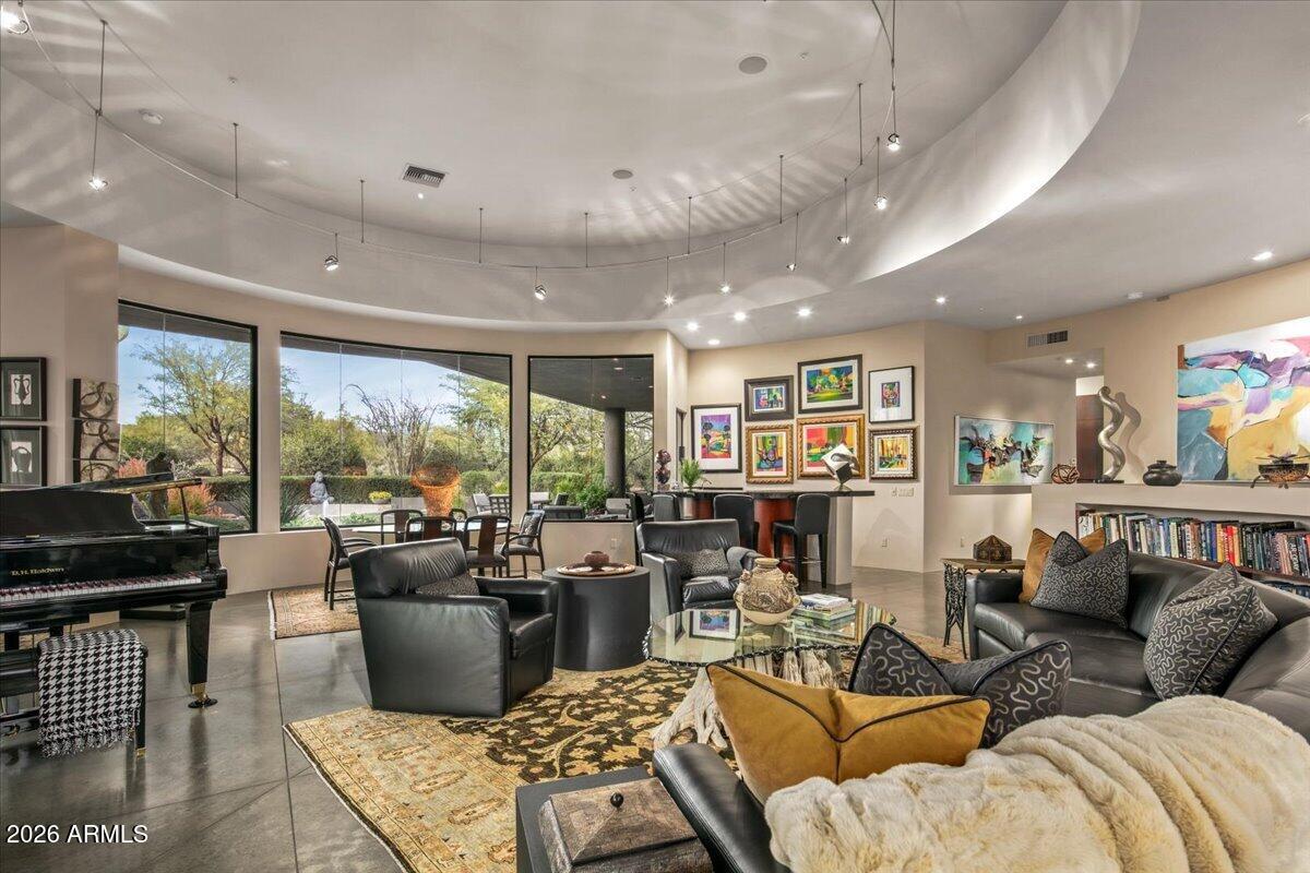 IMMEDIATE GOLF MEMBERSHIP AT CLOSE OF ESCROW. A true architectural statement in North Scottsdale, this one-of-a-kind residence is defined by its distinctive round design, thoughtfully imagined and designed by the original/current owners to create effortless flow and visual intrigue throughout. Walls of glass frame clear, unobstructed Pinnacle Peak views, filling the home w/ natural light and a constant connection to the desert landscape. The lower level offers exceptional versatility, featuring multiple flex spaces and a private bedroom ideal for a media lounge, wellness retreat, home office, or guest suite. A climate-controlled wine room adds an elegant touch for collectors and entertainers alike. Discreetly tucked away, ascend the hidden staircase (only accessible from the...