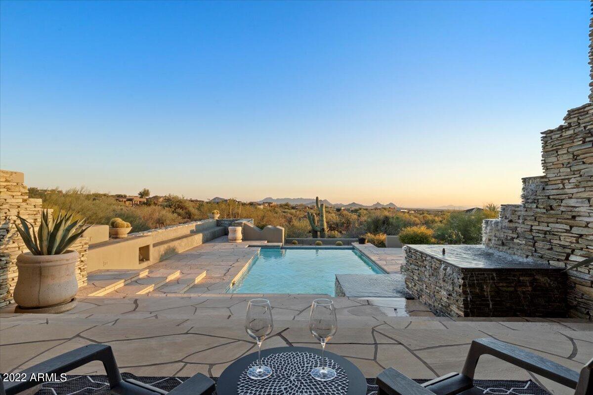 PLEASE WATCH THE NEW VIDEO.  A rare opportunity to own a Bob Bacon designed Custom Home in Desert Mountain perfectly situated on an acre plus premium lot with incredible Mountain, City Light & Sunset views. This home has been perfectly updated and maintained throughout.  The luxurious master suite includes an optional exercise/lounge area. There are 2 additional in-suite bedrooms, an office, 2 powder rooms, Great Room with wet bar, formal dining room & updated kitchen. The outdoor living spaces offer multiple covered patios, a negative edge pool, resort style waterfall, heated spa, Ramada & view deck with fireplace. Desert Mountain offers 7 Jack Nicklaus designed golf courses, state of the art fitness, tennis swim & spa facility including pickle ball & lawn croquet, hiking, biking & walking trails, and great dining.