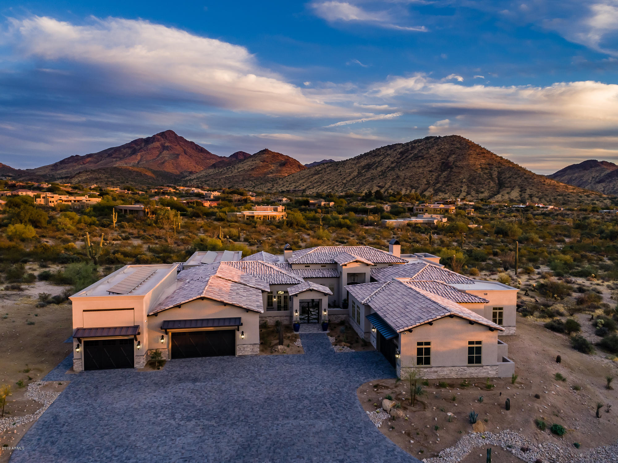 Recently completed new build, ignore days on market. Stunning Custom new build in the Troon area. The ultimate in luxury and smart home technology with breathtaking mountain and city light views.  7924 SF livable with professionally designed interiors and exterior landscaping.  Flexible split floor plan includes 4 bedrooms, 6 baths, 2 play/bonus rooms, 2 offices, gym/5th bedroom, a walk in pantry as well as interior and exterior storage rooms.  An attached casita with private courtyard entrance adds an additional full kitchen, living area and a 6th bedroom/bath suite.  Unique ceiling and millwork details create a truly one of a kind luxury home that is just over 11,600 SF under roof.  This home has many hard to find features such as an 8+ car garage which includes a full size RV garage The 12' W x 16' High RV airplane hangar garage door is designed that when closed is concealed to blend in with the rest of the house and give the appearance of a standard size garage door.  Smart home technology includes automated thermostats, pool controls, window coverings, hidden TV's and security system.  With the extensive spray foam insulation, photovoltaic solar system with demand monitoring technology and supplementary solar pool heating it is estimated that this expansive property will operate with little to no electric bill year round.  Other features include custom cabinetry, 400 bottle wine enclosure, Wolf / Sub Zero appliances, luxury finishes in kitchen and every bath, electric vehicle charging station, great room with 17' tall ceilings and a powered 16' x 10' sliding pocket door which hides away to reveal the amazing views.  This home is the best of the best in construction quality, luxury design and technology and is awaiting it's new owners.
