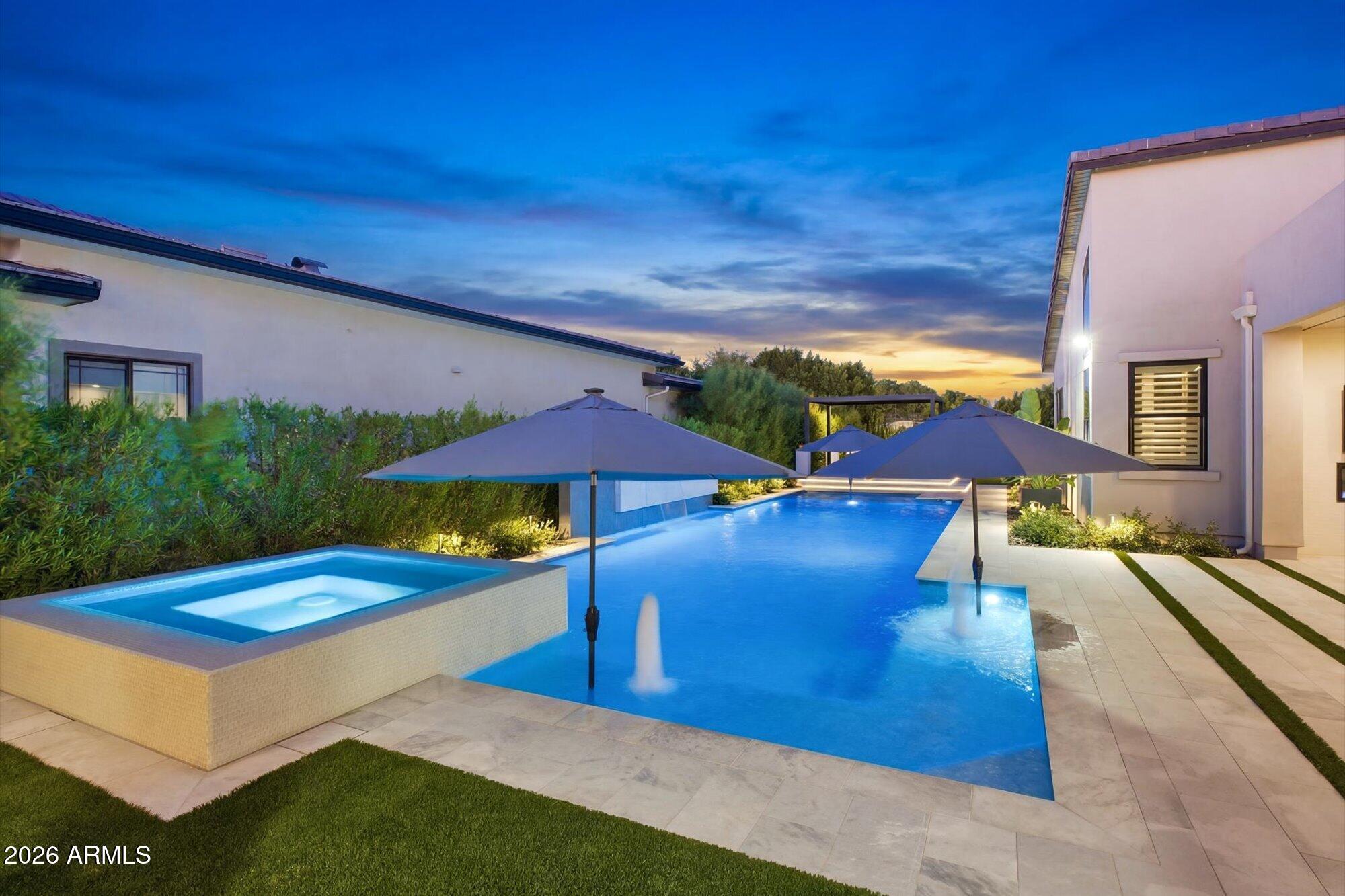 VOTED BEST HOME!!  Situated on a premium corner lot directly across from the community park in Toll Brothers' sought-after Caleda community, this stunning, model-perfect home, boasts more than $600k in designer upgrades and custom enhancements, showcasing exceptional craftsmanship and luxurious finishes throughout. A dramatic entrance welcomes you into the expansive great room and designer kitchen, both overlooking an enchanting outdoor retreat designed for seamless indoor-outdoor living. The front of the home also features an intimate courtyard patio space, creating an inviting setting for morning coffee or evening relaxation.
The dream kitchen is truly a showpiece, featuring an impressive 12' x 5' quartz waterfall island, Sub-Zero refrigerator, freezer and 24'' column wine refrigerator, beverage refrigerator, 18'' built-in ice maker, double ovens, a 48" six-burner gas range, custom under-cabinet lighting, and a spacious walk-in pantry complete with custom built-ins.

The great room offers a sleek linear fireplace and dramatic 20' multi-slide pocket doors that open effortlessly to the covered patio, featuring its own linear fireplace and curated custom details that create the ultimate Arizona indoor-outdoor lifestyle. The spectacular primary suite is a luxurious private retreat with a cozy fireplace, dual custom designed closets, separate floating vanities, an oversized spa-inspired shower, and a freestanding soaking tub. Custom wall treatments adorn the secondary bedrooms, adding warmth and sophistication throughout the home. The fourth bedroom has been thoughtfully transformed into a sophisticated private study, featuring custom maple shelving that adds warmth and timeless character and has its own en-suite bath. The powder room has been elevated with a beautiful Restoration Hardware sink and designer finishes.

The three car garage has finished floors, ample built-in storage along with an EV charger.

Designed for exceptional entertaining, the backyard oasis features a custom ramada with a fully equipped outdoor kitchen complete with a stainless steel gas BBQ, EVO flat-top grill, rinse sink, storage drawers, and drink cooler. The stunning 24,000-gallon saltwater pool showcases two large Baja shelves, LED lighting, partial in-floor cleaning system, and an AquaCal heat/cool pump and gas heater that allows the pool to be heated or cooled year-round. The oversized spa, beautifully encased in sea glass, spills directly into the pool, creating a true resort-style ambiance. Multiple gathering and lounge spaces including a raised seating area beneath a pergola along with a putting green complete this exceptional outdoor retreat.

Located within a private gated community and just moments from premier shopping, dining, and entertainment, this one-of-a-kind residence offers luxury, comfort, and impeccable attention to detail at every turn.