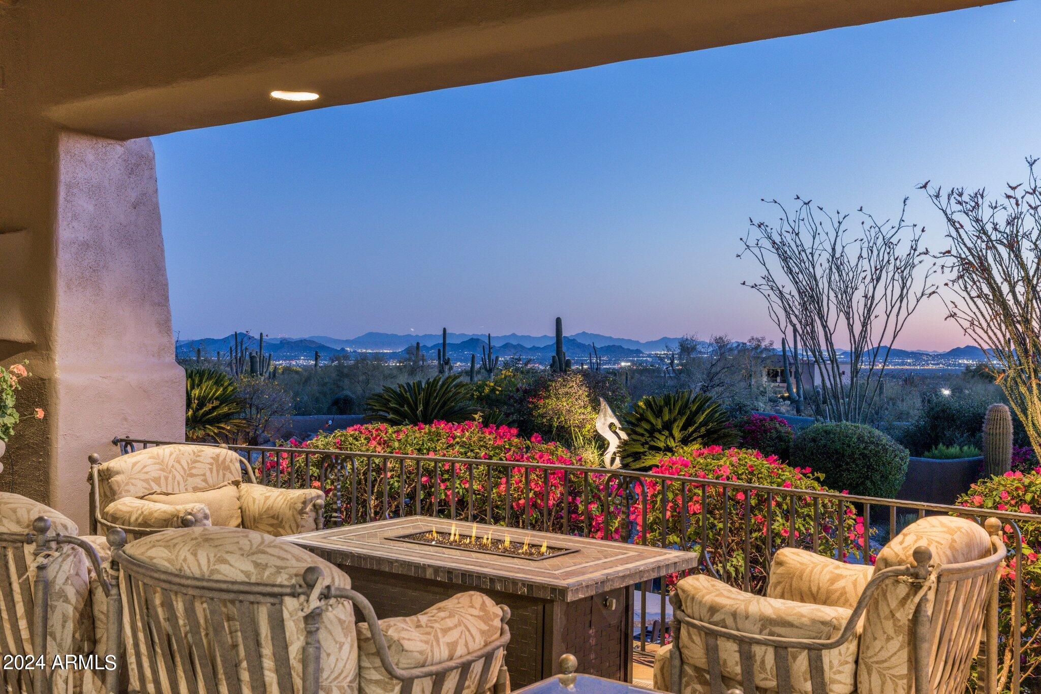 Be prepared to be in awe at this dramatic Southwest Contemporary Estate located on nearly 3 acres w/ dramatic city light, mountain, & sunset views. Start enjoying the good life right away, not only is this home being sold fully furnished w/ dishes & linens it also comes with a full Golf Membership to Desert Highlands, one of the most prestigious guard gated country clubs in the Southwest; w/ a Signature Jack Nicklaus 18 hole Golf Course, 18 Hole Putting Course, 13 meticulously manicured grass, clay, & hard court tennis courts, state of the art fitness center, as well as a first class club house featuring dramatic views w/ casual & formal dining & concierge services! This one of a kind estate overlooks the entire valley and beautiful lush Sonoran desert... The impressive and ultra private grounds are extremely low maintenance and include a circular drive entry, charming entry courtyard, expansive covered patios and sunning decks, a refreshing pebble tec pool, oversized spa, and its own private artificial turf tennis court made specifically for tennis and pickleball, as well as a private guest house with its own entry, family room, guest suite and bathroom with steam shower.  The main house was designed with entertaining in mind and is centered around a spacious great room complemented by a wrap around wet bar, dramatic fireplace, dining room, warm wood ceiling details and floor to ceiling windows to take in the phenomenal valley and mountain views.  The open flow continues around the great room to the den which is centered on Pinnacle Peak with its own full bathroom, then on to the gourmet kitchen with a charming fireplace, breakfast room and hearth room.  Not only does the owner's suite feature lay down city light views of the valley below and a fireplace, it also features separate his and her's bathrooms each with their own walk-in closets, vanities and commode rooms, with a shared steam shower in the middle and a free standing tub with Pinnacle Peak views on the Her's side.  Guests will have a hard time picking between the private guest casita, the guest suite with city light views, or from a Jr. master with its own private family room / den and courtyard access.   From privacy to mountain views, to city light and valley views, to an amazing floorplan with no steps, this home truly has it all.