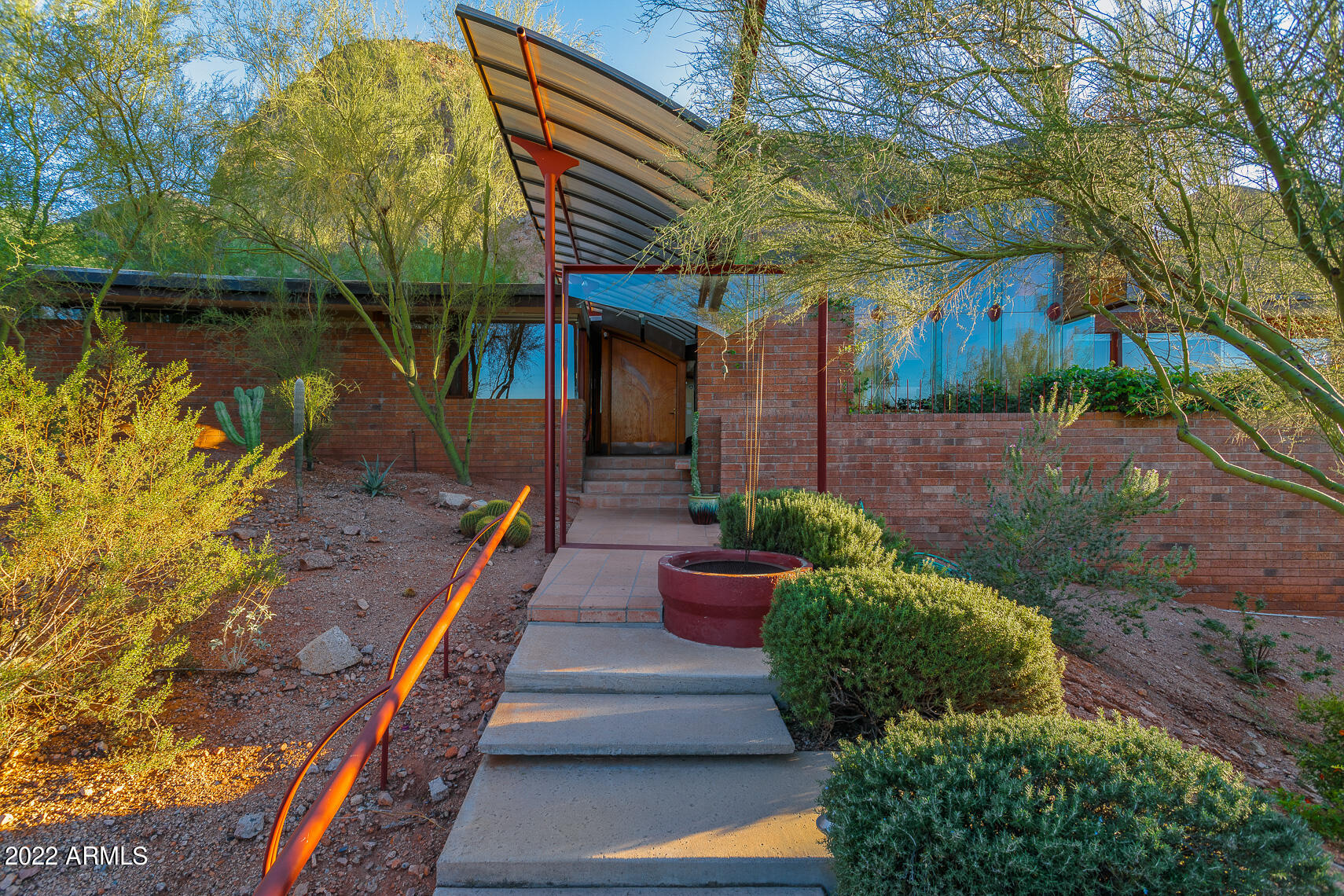 HOT NEW PRICE!  Expressive Design integrated w/ nature & sweeping PV views.  The Halas House by ''Master of the Southwest'' Architect Eddie Jones FAIA- A Desert Modern Architectural gem well published is nestled into its Camelback Mountain Hillside lot. Incredible construction palatte: amazing details/custom elements. Soaring ceilings, full height glass walls bring in views! No detail overlooked: redwood ceilings, oak floors/millwork. kitchen offers wonderful workspace/storage. Perfect-sized great room w/custom fireplace, formal dining. 3 br, one doubles as office. Guest room has entrance/ en-suite bath. Solarium, private patios, stunning lap pool! Generous Owners-Suite. 3-Car garage w/storage/shop. View corridor looks across Valley! Immaculately kept. History & MORE Camelback Mountain- The Halas House - Eddie Jones FAIA Architect
There are so few homes remaining that represent the "Arizona School" of Desert Modern Architecture other than the Halas House designed by Award-winning, "Master of the Southwest" Architect Eddie Jones, FAIA. Immaculately kept by the original family, this home is being offered for the first time ever. Featured in many publications, this award-winning home nestles into its Camelback Mountain hillside site offering a quiet, yet expressive design well integrated into nature, with commanding views of Paradise Valley. The home offers brick masonry and copper construction, simply amazing detailing and custom steel elements. Soaring ceilings make the volumes feel more spacious and the full height glass walls bring the views and outdoors in. Not a single detail was overlooked in this custom home. The main ceilings feature a half barrel vault in redwood while the custom millwork is outfitted in white oak. Open kitchen offers a plethora of storage and wonderful natural light, a gift from the round skylight details found throughout this home.

The plan is generous, flexible and perfectly sized; including a great room anchored by the circular masonry fireplace, formal dining and three bedrooms.  One of the bedrooms opens into the owners suite for a convenient full office. The 2nd guest room sports it's own entrance, en-suite bath and built-in fold-down bed, bookcases and private access to the garage. You'll find an enclosed glass solarium that is a perfect place for morning coffee, complete with private side patio with a zen-like water feature. Sheltered and serene. The owners suite offers every detail from the large closet, completely fitted in oak, to the bath suite complete with shower, soaking tub with views, separate double sinks and direct access to the pool. The sparkling lap pool is perfect-sized and ready for entertaining. There's an outdoor shower too!
You'll never lack storage with the three-car garage, deep cabinets and separate shop/ storeroom. The home offers access off Valle Vista Way for easy and private garage entry. Out front there's a circular drive for guests. Well sited, the home is very quiet and elevated well above street level to capture a view across the valley, from Mummy Mountain to Piestewa Peak and beyond! Behind is the glorious rock and desert of Echo Canyon, easily enjoyed poolside or at the private entertaining patio below.

This is a rare opportunity that cannot be duplicated. Pride of continuous ownership is evident in this home and unmatched anywhere else.  This home will be shown strictly by appointment. More Details to Follow.


Features: 
New To Market!
Eddie Jones FAIA/Jones Studio Architect
Award-Winning Published Design
Paradise Valley Hillside Lot
Nestled on Camelback Mountain North Slope
Sweeping Views of the Valley
Completely Custom: Brick, Copper, Steel and Glass Construction Sparkling Lap Pool
Private Patios and glassed Atrium
Half Barrel Vault Ceiling in Redwood
Inspired Custom Fireplace
Full House Glass Walls & Metal Accents
Circularity of Design is Replicated
Sheltered Canopy Entrance for Guests
3-Car Garage with Shop/Storage
Dual Driveways for Guests and Owners
Copper Cladding Surrounds Roofline
Attic for additional Storage & Access
Featured in Book: Paradise Valley Architecture
Acre Lot w/ Double Street Access
Pride of Continued Family Ownership Since New. 
Irreplaceable at the Offering Price!
More Details to Follow
