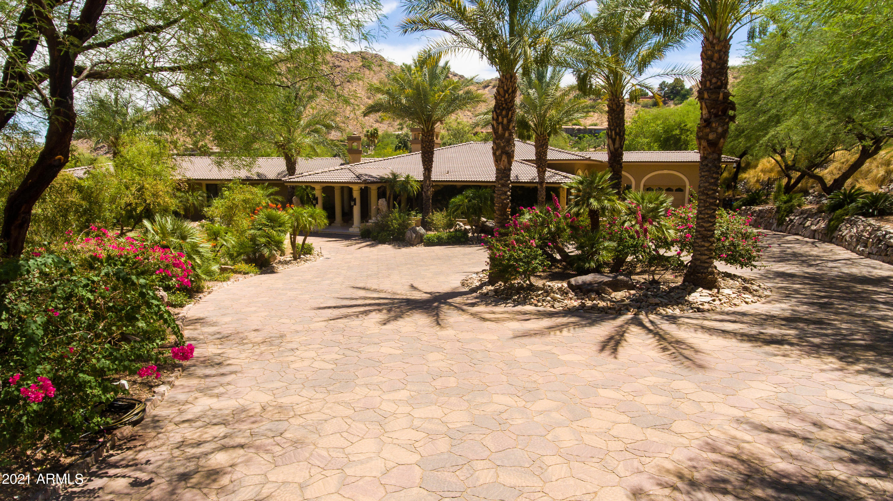 Private gated estate in the heart of Paradise Valley with 360-degree mountain views. Enjoy the resort style backyard with pool,  tennis court, lush landscape and wrap-a-round patio. Fabulous for entertaining! Featuring a free standing guest house with 2 bedrooms 2 baths full kitchen and great room. Dramatic architecture designed by Dave Hansen. Polished stone floors, high end appliances, wine room, billiard room, den and split master retreat with access to amazing backyard views.  You will enjoy the privacy on this mountain view home with high end finishes, state of the art lighting and high end security system.  Decorative custom designed commercial gate at front entrance to provide privacy and security. A true WOW property near Paradise Valley Country Club.