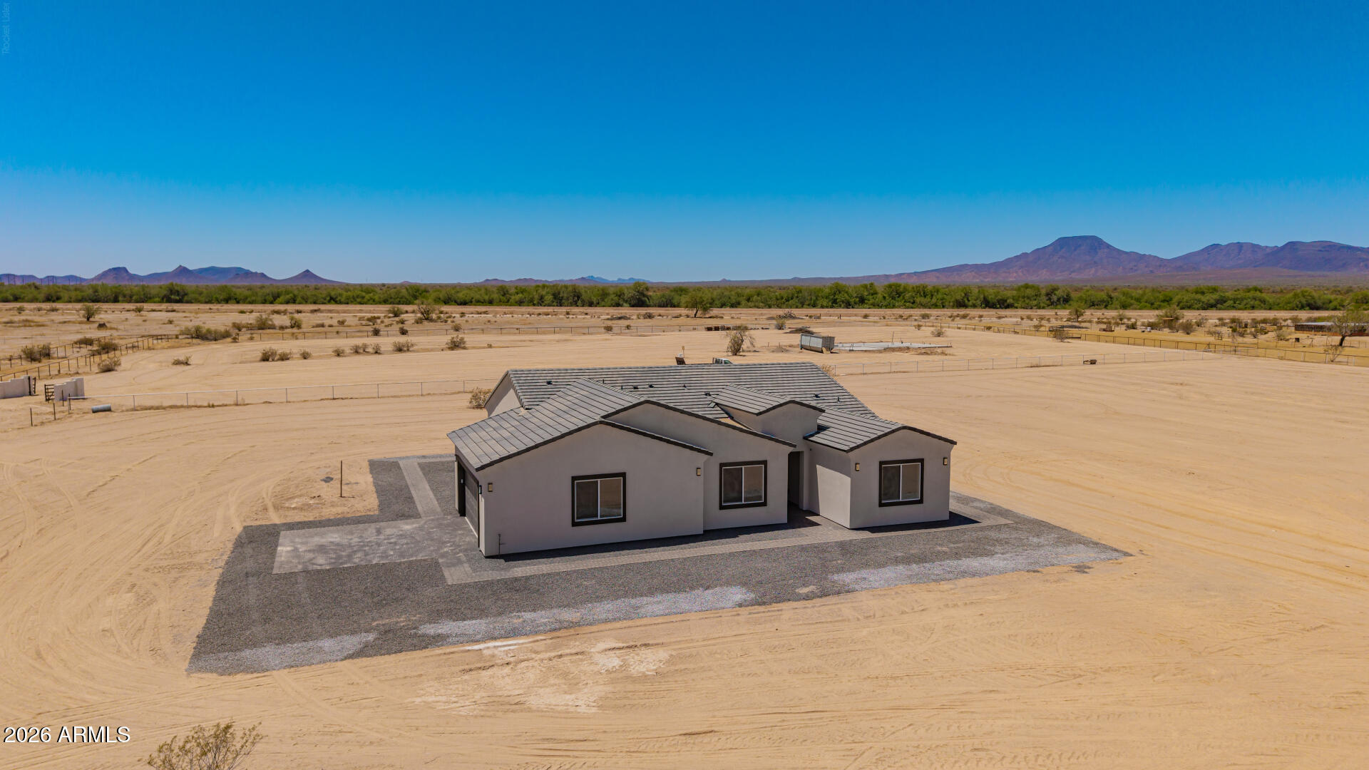 What a RARE gem! This newly constructed horse property offers 3,433 sq ft under one roof with a stunning wraparound porch on 3.74 acres surrounded by custom homes and no HOA. Fully fenced with a custom entry gate, this estate delivers luxury, privacy, and open space rarely found in today's market. Inside features soaring 10-ft ceilings, an open layout, abundant natural light, recessed lighting, designer finishes, tile and wood flooring, and a beautiful fireplace. The chef-inspired kitchen showcases built-in appliances, custom cabinetry, and ample storage. Featuring 4 bedrooms, 2 full bathrooms, plus a powder room with plenty of room for horses, RVs, trailers, and toys. Check out the covered patio, where you can relax while enjoying tranquil mountain views! Let's not forget the 2-car garage Check out the covered patio, where you can relax while enjoying tranquil mountain views! Let's not forget the 2-car garage, complemented by paver driveway & pathways. PLUS! A premium water well enhances self-sufficiency. The vast acreage provides endless possibilities - whether you envision space for horses, recreational vehicles, or simply room to enjoy the open desert landscape. Don't miss this incredible opportunity!