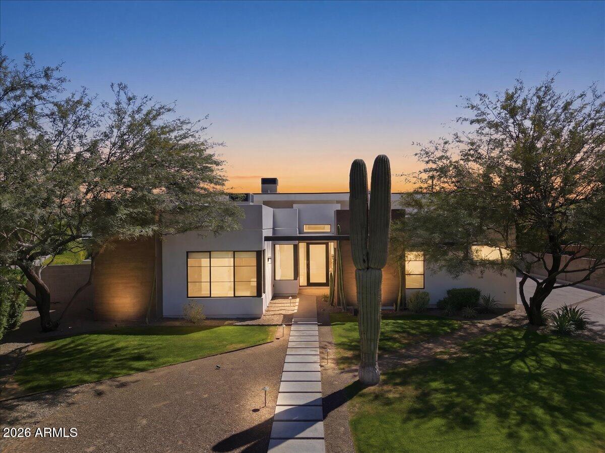 Clean architectural lines, soaring ceilings, and seamless indoor-outdoor living define this striking residence in one of the Phoenix/Scottsdale/Paradise Valley area's most desirable pockets, Arcadia's Marion Estates. 
Spanning nearly 3,700 square feet, this 5-bedroom, 4.5-bath home is thoughtfully designed with both scale and livability in mind. Expansive glass, dramatic ceiling heights, and a soft contemporary palette create a light-filled environment that feels both refined and effortlessly comfortable. Wide-plank wood flooring with a curated, weathered finish adds warmth and character, complementing the home's modern architectural lines. Three secondary bedrooms feature en suite baths, while an additional bedroom upon entry offers flexibility as a guest room, office, or creative space. At the center of the home, a stunning chef's kitchen anchors the space with an oversized island, gas appliances, double ovens, and a brand-new cafe refrigerator--all framed by custom cabinetry and designer lighting. The kitchen flows seamlessly into the main living area, where oversized sliding doors open to a true resort-style backyard.
Outdoors, a private oasis awaits. A sleek pool with water features, shaded lounge spaces, built-in grill with adjacent pizza oven, and multiple entertaining areas are perfectly positioned to capture views of Camelback Mountain, including the iconic Praying Monk. The result is a setting that feels both elevated and relaxed--ideal for everyday living or hosting at scale.
The primary suite is a retreat unto itself, featuring generous proportions and a spa-like bath with a soaking tub framed by those Camelback views--an everyday moment that feels anything but ordinary.
Additional highlights include a dedicated office or flex space, north/south exposure, and a rare three-car air-conditioned garage.
Located just moments from great schools like Hopi Elementary and Phoenix Country Day School and some of the Valley's most sought-after destinations--including The Global Ambassador, Steak 44, and Arcadia's vibrant dining scene--this home offers immediate access to both lifestyle and convenience. Nearby Camelback trailheads complete the experience for those seeking an active, outdoor lifestyle.
A rare blend of modern design, volume, and location--this is elevated desert living, done right.