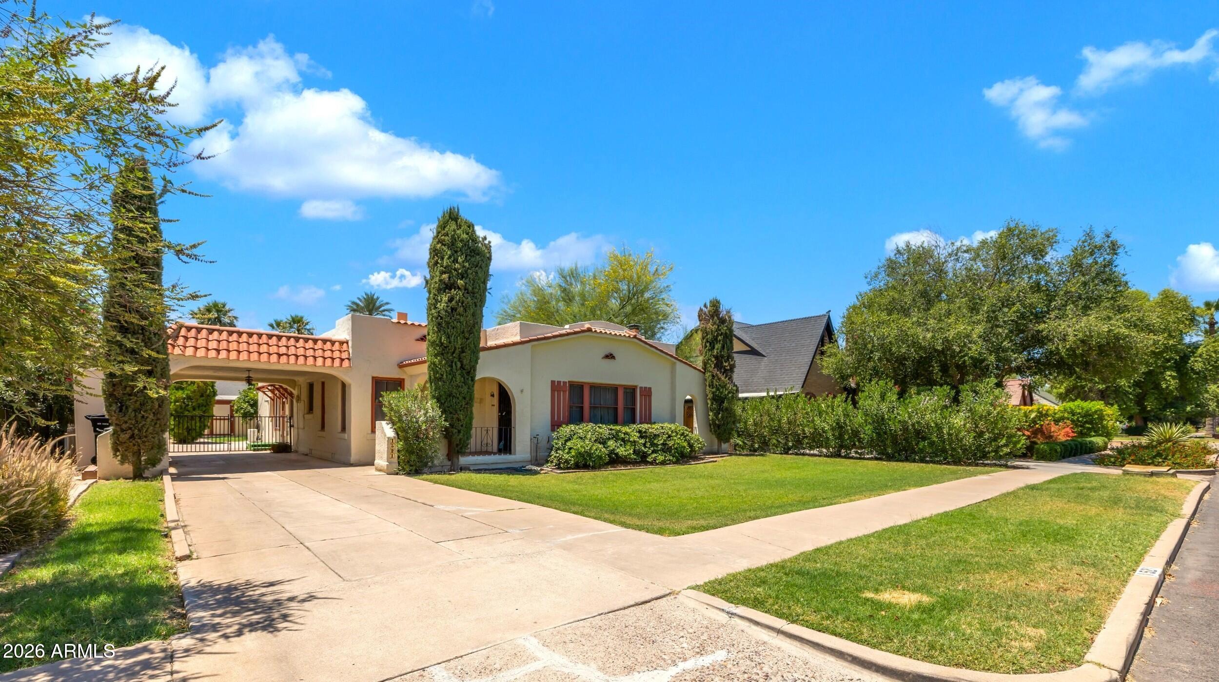 Charming Spanish Revival in the Cheery Lynn Historic District, one of Phoenix's 35 designated historic neighborhoods. This home offers a cozy living room with fireplace, separate dining area and galley kitchen that opens to a brkfst area & enclosed rear space ideal as family room, complete with a mini-split heat/ac. A separate hallway leads to expanded primary suite with private bath. All added square footage permitted, including rear
utility and filtration closet.  Additional square footage verified in recent appraisal. Historic details shine with original hardwood floors,
arched doorways, plaster walls, and crystal knobs, complemented by updated cabinetry, gas range, charming backsplash & plantation shutters . Lush landscaping,
and a covered patio complete the inviting backyard retrea