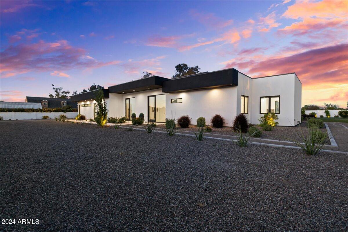 Welcome to your dream contemporary home, a stunning example of modern living blending seamlessly with comfort and luxury. Built in 2022, this exceptional property offers a spacious 4,790 sq ft of interior living space with an additional 900 sq ft detached casita with separate bedroom and full ensuite set on a 1.25 acre beautifully landscaped lot that emphasizes both privacy and open spaces. Entering the property through a secure gated entrance, you're greeted with an open concept kitchen and living room area, designed for both entertaining and everyday living. The kitchen is a chef's delight with two dishwashers, commercial-grade appliances and expansive center island. The home boasts 4 bedrooms and 4.5 bathrooms, including a luxurious primary suite with a steam shower for ultimate relaxation and each of the other bedrooms offering luxurious en-suite bathrooms. High 20-foot ceilings and commercial-grade windows flood the space with natural light, enhanced by automated window treatments for privacy and comfort. A Savant smart home system places control of the home's features at your fingertips. The home is also equipped with a whole home water filtration system.  Additional amenities include a game room, an office for those work-from-home days and a bar for entertaining. The living space extends effortlessly outdoors thanks to wall-to-wall glass doors, leading you to over 1,000 square feet of covered patio overlooking a resort-style pool. The outdoor area is complete with two outdoor fireplaces, built in barbeque, outdoor shower, heaters and entertainment features like a sports court/pickle ball court, putting green and additional space to add any other features you may want. Don't miss the opportunity to own this beautiful home.