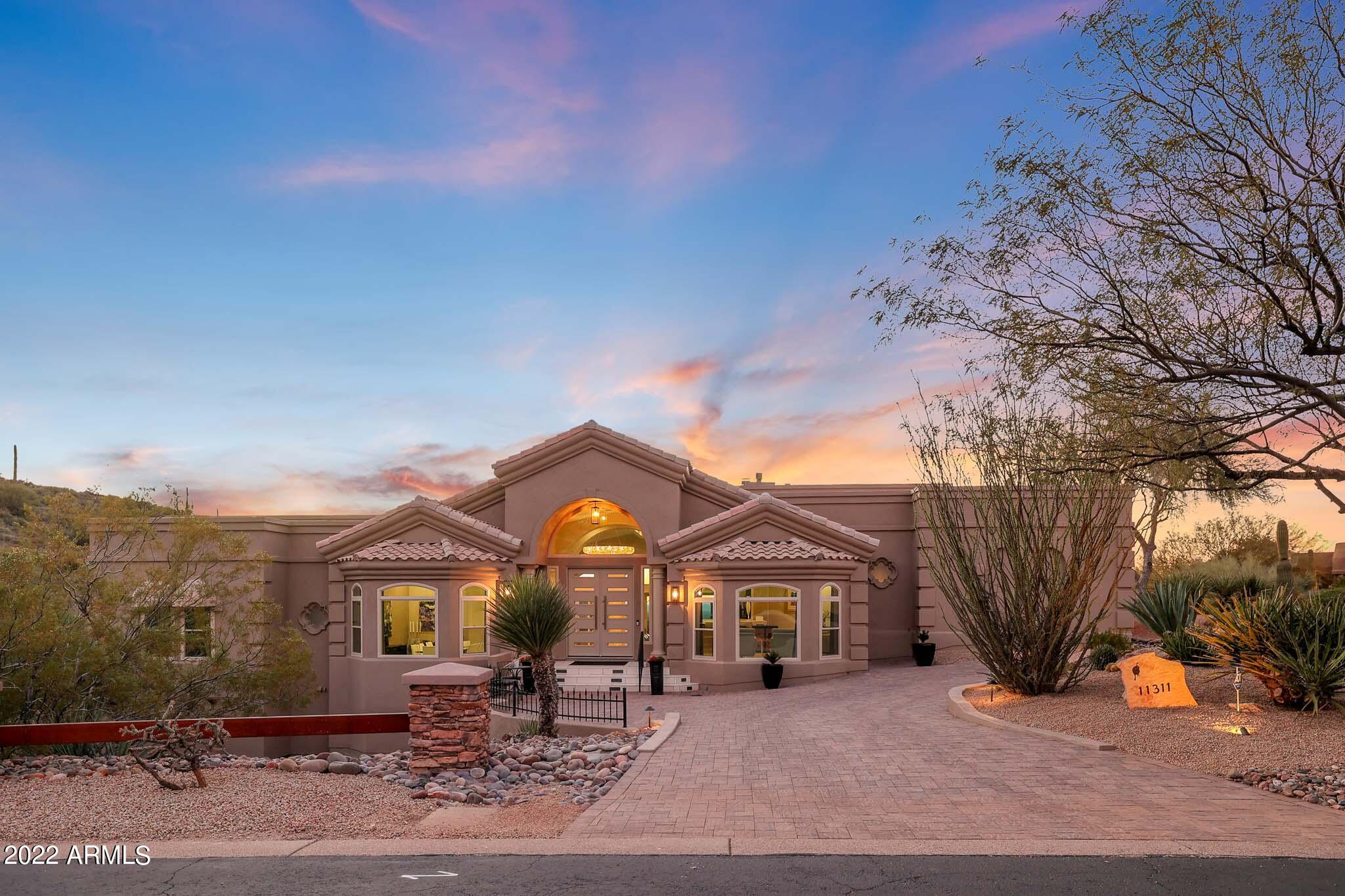 Here is your opportunity to own this stunning home in the gated community of Troon Ridge Estates! This 4 bedroom, 4.5 bath is situated on 1.44 acres with exceptional one-of-a-kind 360-degree views of the valley and its sunsets. Nothing has been spared in the renovation of this 4500 square foot home, inside or out. This home offers all the amenities and convenience that you come to expect in a modern home. As soon as you enter the home you can see what separates this home from others. The spacious floor plan is the ultimate in luxury featuring Italian marble flooring, Hievonynas chandelier, tray ceilings, modern luxury fireplaces, arched openings, new windows, new doors, and HVAC systems. The Imported Poggenpohl German kitchen features custom cabinets and drawers, state of the art Samsung and Miele appliances, induction cooktop, porcelain, and quartz counters. The eat in kitchen has full retractable pocket doors to enjoy the spectacular outside views. The primary bedroom features a floor to ceiling slate fireplace, plank flooring and double doors leading to your own patio with spectacular mountain views. The ensuite features marble flooring, dual access walk-in shower, and large elegant soaking tub. With two other bedrooms and ensuites on the primary level, they offer modern luxury and privacy with their own amazing views.  The lower level of the house features the spacious fourth bedroom and it's ensuite. The outdoor resort like living area boasts multi-levels for entertaining with a built-in outdoor kitchen. You will enjoy sitting by the fireplace with a bottle of wine or relaxing in the heated pebble shine pool and spa all while enjoying some of the best views and sunsets the valley has to offer. While in the climate controlled three car extended length garage, you'll find a bonus room ready for any of your office, art, crafts or workout needs. Within Troon you will be able to enjoy some of the finest dining, world class events and amenities Scottsdale has to offer within a short distance from your door.