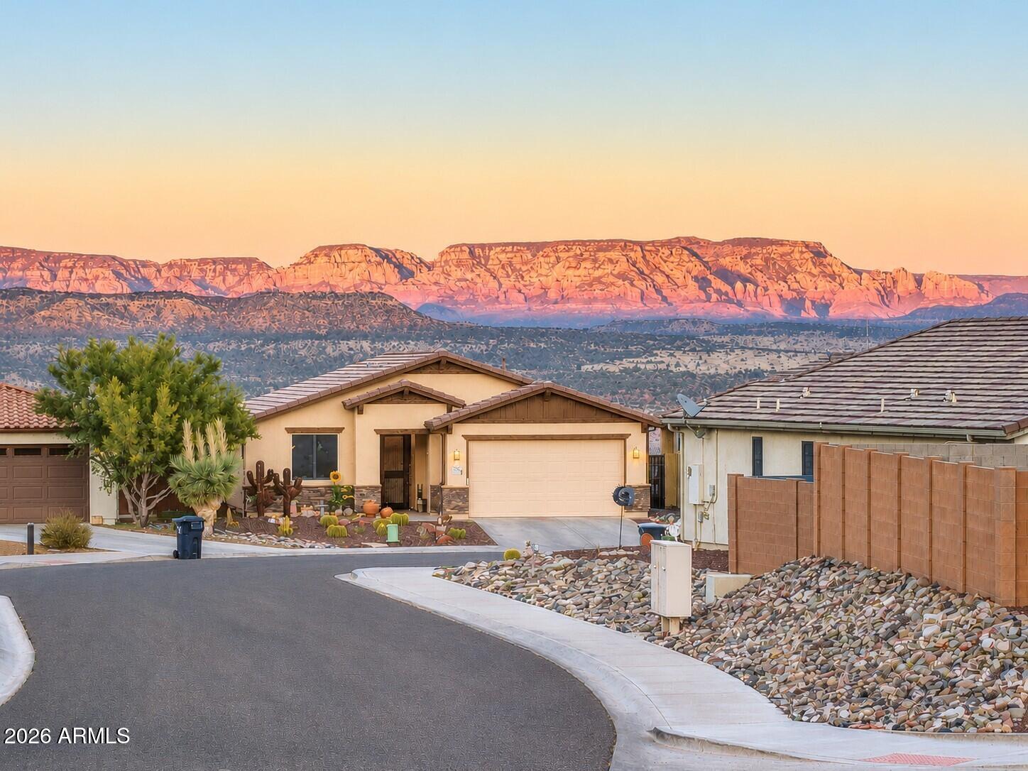 Enjoy distant views of Sedona's iconic red rock mountains and stunning sunsets from this well-maintained Energy Star home. Featuring two bedrooms plus an office/den, this spacious 1,645-square-foot residence includes a post-tension foundation, fenced/walled backyard, fire sprinkler system, reverse osmosis system, water softener and drip irrigation system.

The living room boasts a newly added stone gas fireplace, while beautiful, sculpted engineered wood flooring enhances the home throughout. The kitchen and bathrooms are appointed with granite countertops.  Kitchen has newer stainless-steel appliances and a reverse osmosis system, touch sensor facet, pot filler and upgraded gas range and oven.  Primary bedroom has outside access, and ensuite bath offers double sinks, 2-person shower and double closets.

Backing to open space, an arroyo and City of Cottonwood land, the backyard offers spectacular red rock views and privacy!  A six-person spa is included in the sale. All other furnishings are available for purchase.