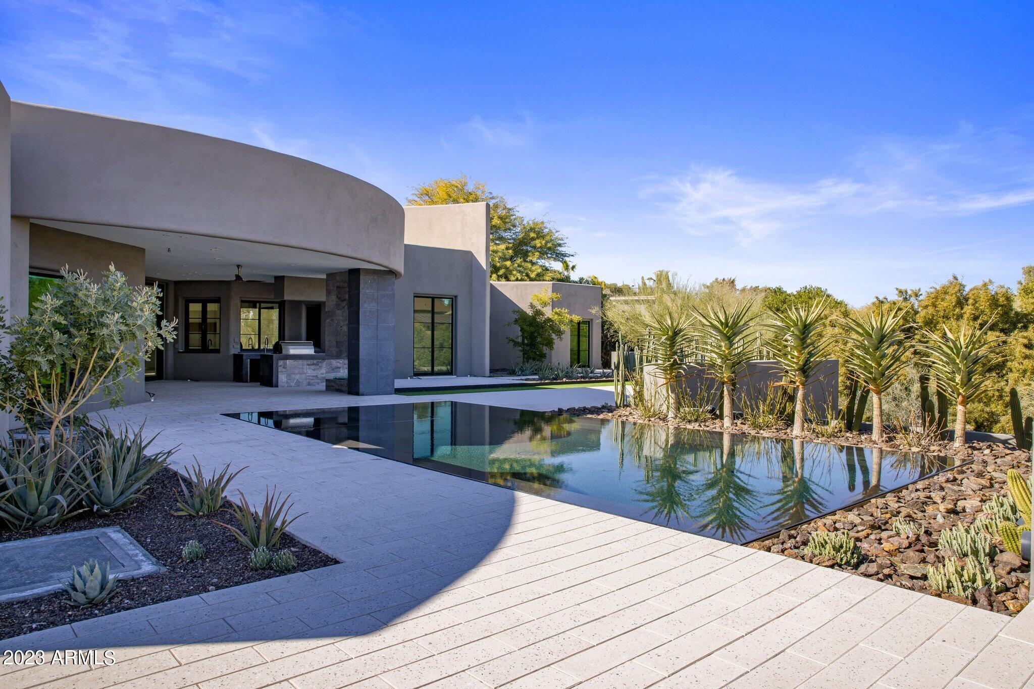 You've found the Paradise Valley property that you've been dreaming of! Beautifully 2023 remodel with no expense spared, this modern desert estate is a welcoming sight. The dramatic front door guides you through this open concept floor plan with high ceilings, stunning gas fireplace and high end chic finishes. The gourmet kitchen features an oversized waterfall quartz island, gas range, double oven, custom cabinetry and spacious walk-in pantry. The indoor/outdoor wet bar is the perfect accent for hosting. Unwind in the incredible primary suite overlooking the sparkling pool and features a spa-inspired bathroom and generously sized clothing closets.  Three additional en-suite guest bedrooms and a 3 car garage make this home a dream come true. Meticulous and low maintenance landscaping wit jaw dropping negative edge pool and panoramic mountain views. Originally built in 1999, but totally taken down to studs and remodeled in 2023. Don't wait or you will miss out!