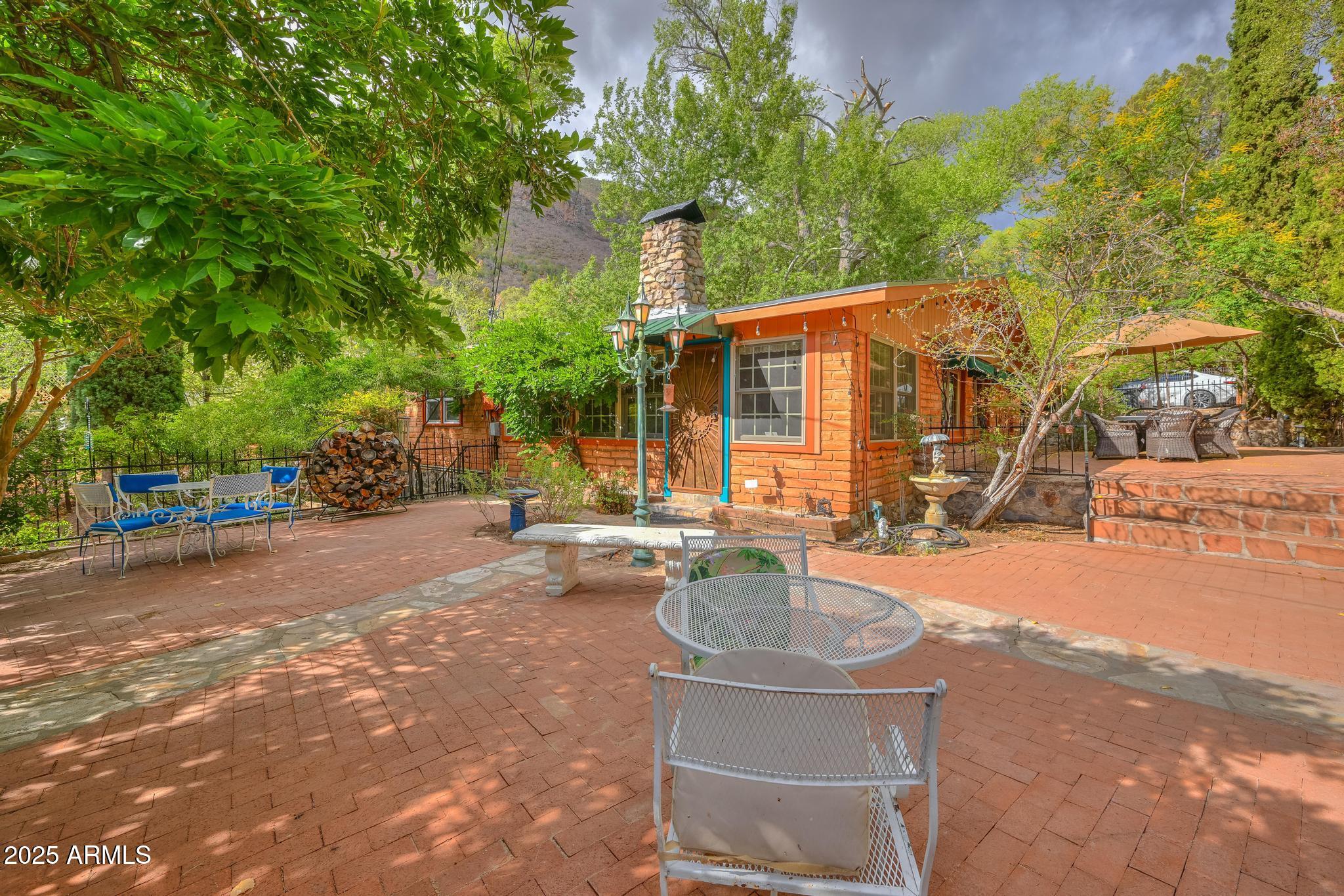 Live in absolute timeless beauty in this 1930s gem nestled on over 4 wooded acres bordering Coronado National Forest. This 3BD/2BA, 2,400 SF retreat features slate & wood floors, a 1934 rock fireplace, 4-season AZ Room, and primary suite w/gorgeous bathroom, clawfoot tub, and stunning views from a private deck. The custom European-style kitchen offers cherry cabinetry, wine cooler, and pantry w/rotating shelves. Enjoy abundant wildlife, amazing seasonal creek, irrigated fruit orchard (50 trees), shop w/outdoor shower, and multiple patios for entertaining and enjoyment. A birder's paradise in Ramsey Canyon beside the Arizona Folklore preserve and walking distance to Nature Conservancy. This private outdoor sanctuary offers rich soil, 3 wells, and one-of-a-kind charm.