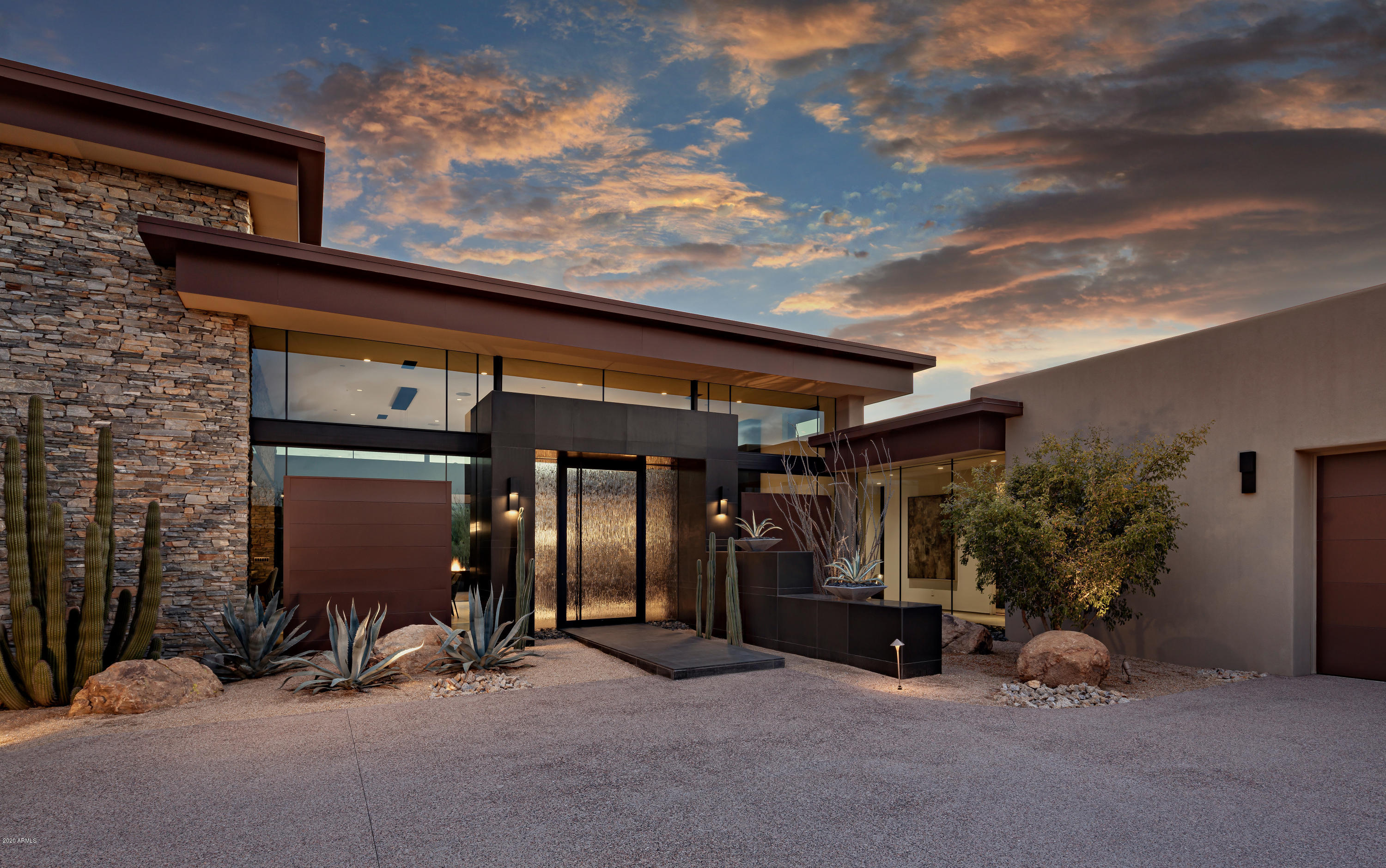 Designed by Tate Studios with interiors by Ownby Design, this architectural masterpiece includes an elegant blend of glass, steel and natural stone * Ideal, open floor plan with seamless kitchen/great room, master bedroom and 3 guest suites on the main level with no interior steps and a guest suite or office with views on the upper level providing the flexibility for 5 bedrooms * South-facing lot provides winter sun on the pool and outdoor living area plus Pinnacle Peak views * Outdoor living includes a large covered patio, outdoor kitchen and bar area, fire place, heated pool/spa and professional landscaping * 4-car garage *
