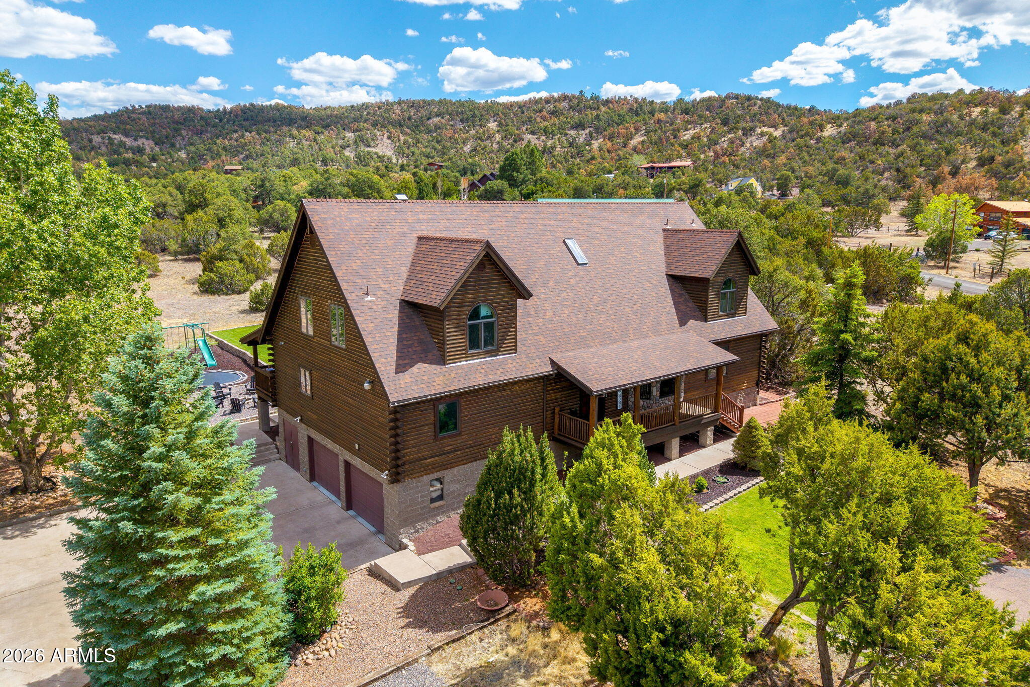 Nestled in the breathtaking mountains of Round Valley, this one-of-a-kind custom-built log home blends rustic charm with modern luxury -- and over $100,000 in recent updates means it's truly move-in ready.
Step inside and you're immediately greeted by soaring ceilings and an expansive open-concept living room and kitchen, designed with entertaining in mind. The custom skip-planked hickory hardwood floors are a true showstopper -- built to last a lifetime and sure to impress every guest.
The primary bedroom is conveniently located on the main level, complemented by a beautifully remodeled en-suite bath. Upstairs, a spacious loft and game room offers the perfect retreat for kids -- complete with a secret attic hideaway they'll never want to leave. The lower level features an oversized two-car garage, a massive dedicated storage room, a separate toy/motorcycle room, and a flexible bonus space ideal as a home office. With over 1,000 sq. ft. of additional storage and workspace not included in the home's square footage, you'll never run out of room. ETS heaters, dual furnace, propane fireplace and dual AC units offer convenience and save on utilities.
When it's time to enjoy the outdoors, step onto the large deck, gather around the fireplace, or let the kids loose on the expansive lawn and playground. Elk and deer make their daily trek up the mountain right outside your backyard and the wildlife views are simply unmatched.  Come see it today!  Seller is listing agent.
