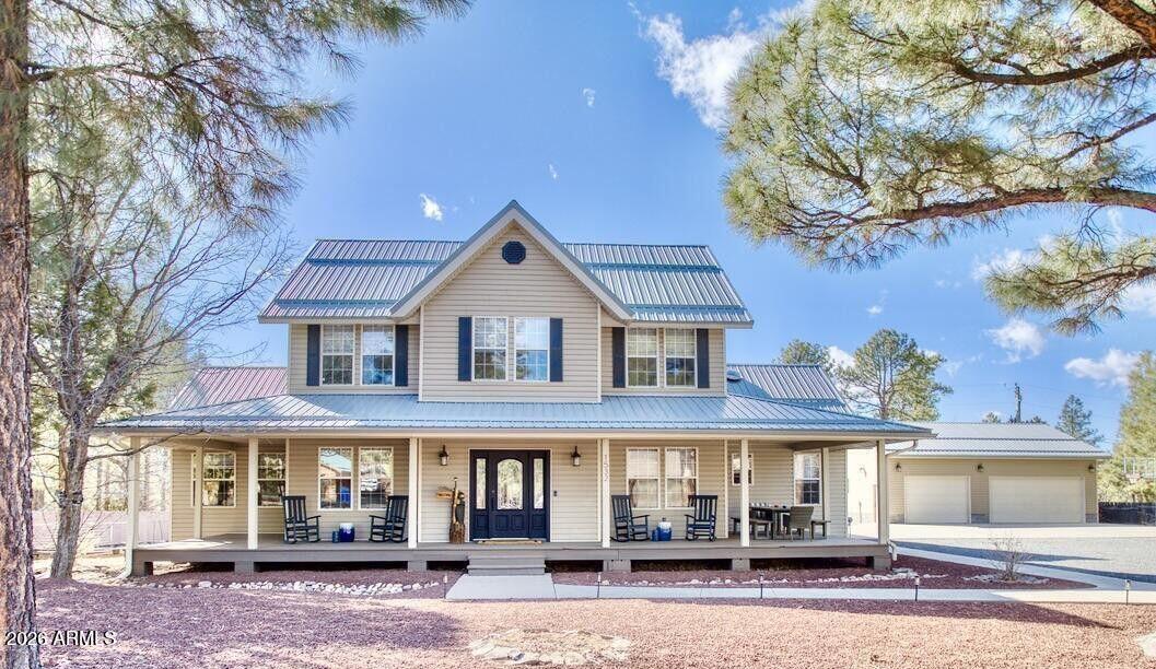 Welcome to the Arizona White Mountains--where tall pines, fresh mountain air, and peaceful living come together.

Set on a rare ¾-acre lot with no HOA, this beautifully maintained farmhouse offers the perfect blend of comfort, space, and privacy. Surrounded by towering trees and with no homes behind you, you'll enjoy a true sense of seclusion just minutes from Rainbow Lake.

Inside, the home features 5 spacious bedrooms and 2.5 bathrooms, along with two inviting living areas designed for both everyday living and entertaining. A fun and versatile game room with a built-in bar adds the perfect touch for gatherings, relaxation, or weekend getaways.
The heart of the home is the stunning kitchen--thoughtfully updated with upgraded cabinetry, quartzite countertops, an apron-front sink, and a dedicated coffee bar complete with a wine fridge. It's warm, functional, and made for both quiet mornings and hosting family and friends.

A detached 4-car garage provides ample space for vehicles, toys, or workshop needs, making this property as practical as it is beautiful.

Whether you're searching for a forever home or a second mountain retreat, this farmhouse offers the lifestyle you've been dreaming of in one of Arizona's most beloved mountain communities.